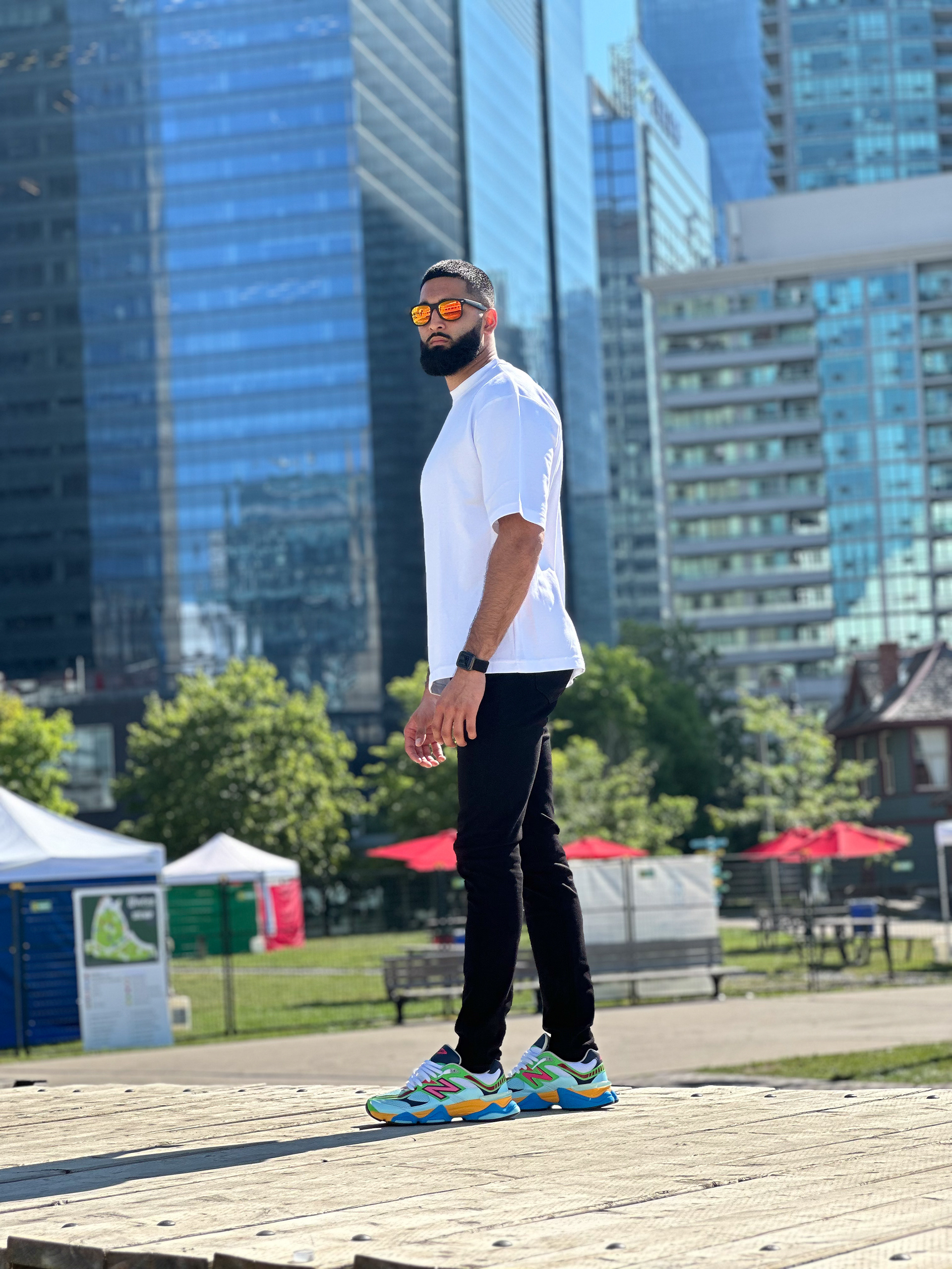 Muhammad Abbasi | Lifestyle | White oversized t-shirt, black jeans, colorful sneakers, side profile walking on dock