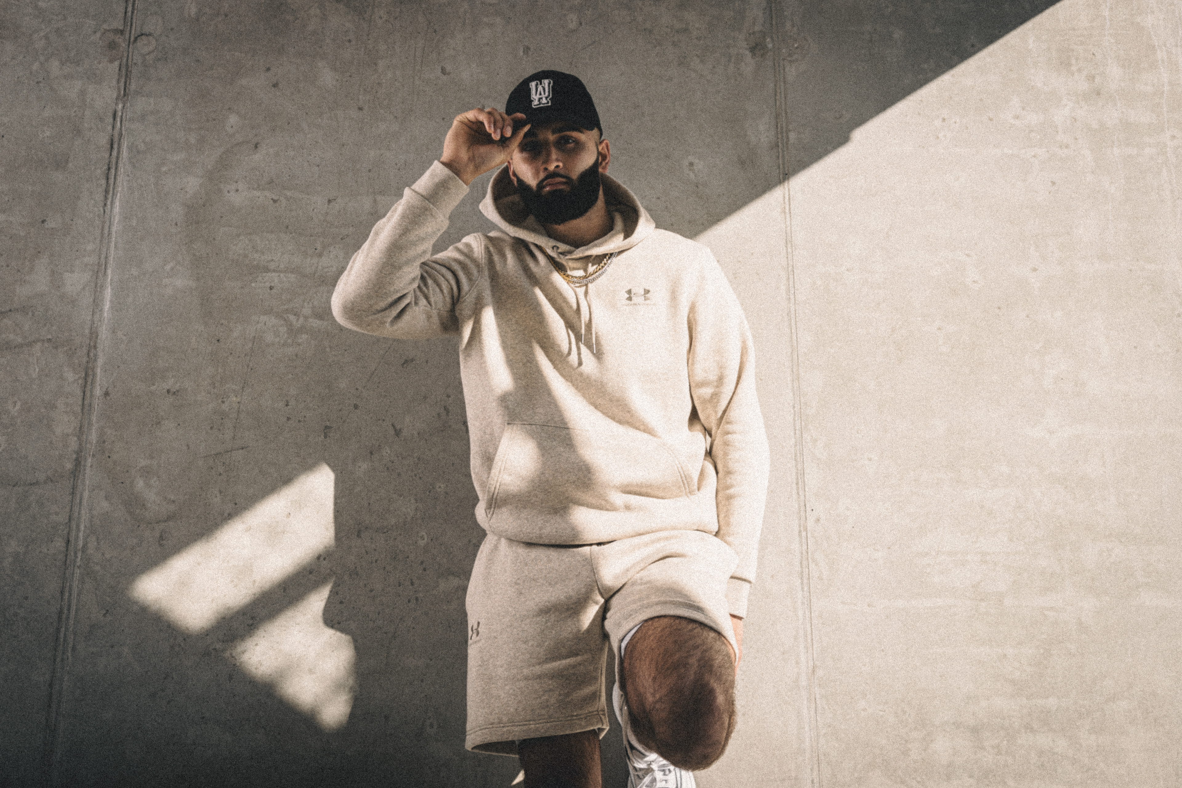 Muhammad Abbasi | Under Armour | ICON Fleece Hoodie | Standing in sunlight with hand on cap