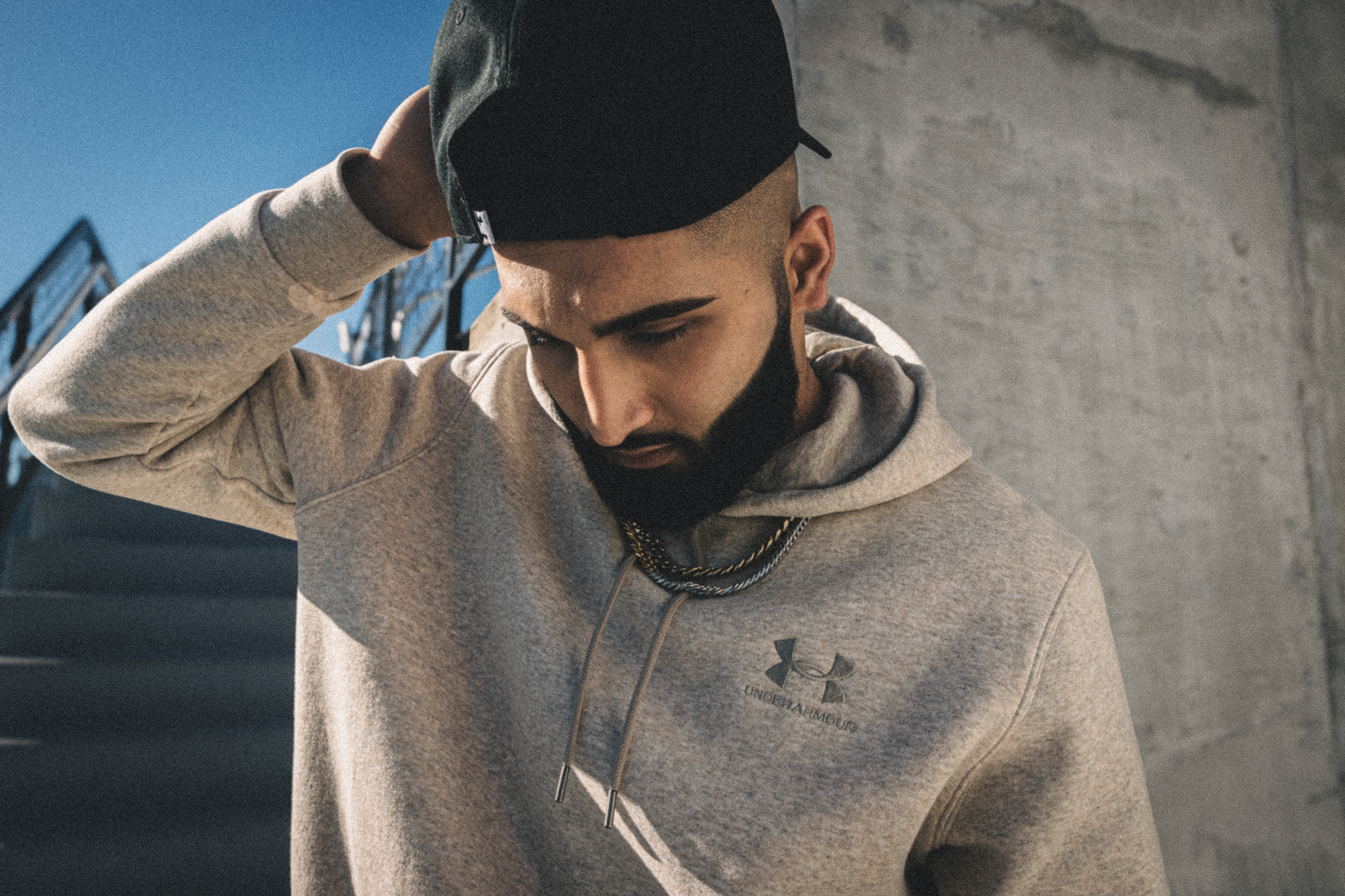 Muhammad Abbasi | Under Armour | ICON Fleece Hoodie | Looking Down in Hoodie on Stadium Steps