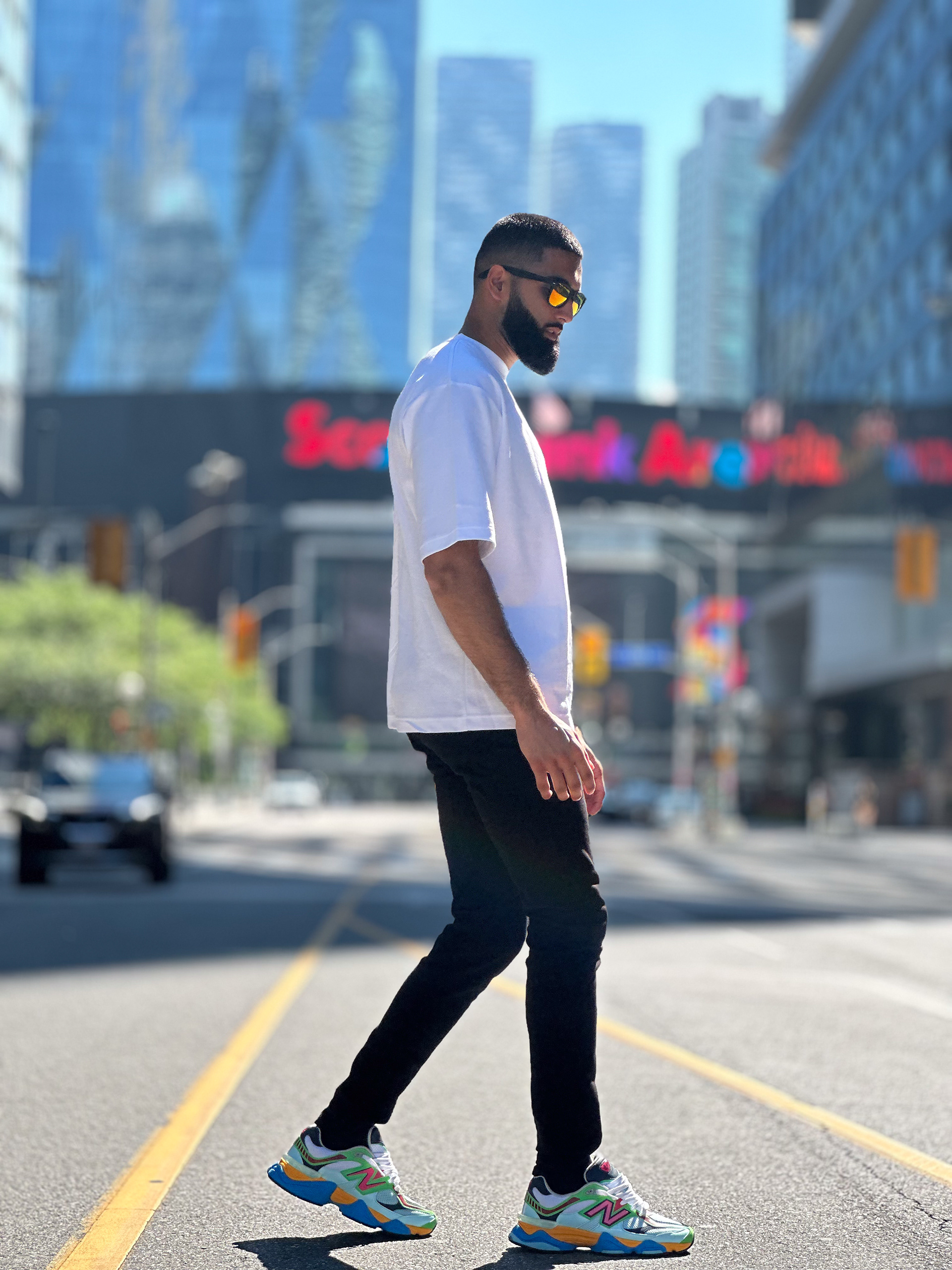 Muhammad Abbasi | Lifestyle | White oversized t-shirt, black jeans, colorful sneakers, side view walking near Scotiabank Arena
