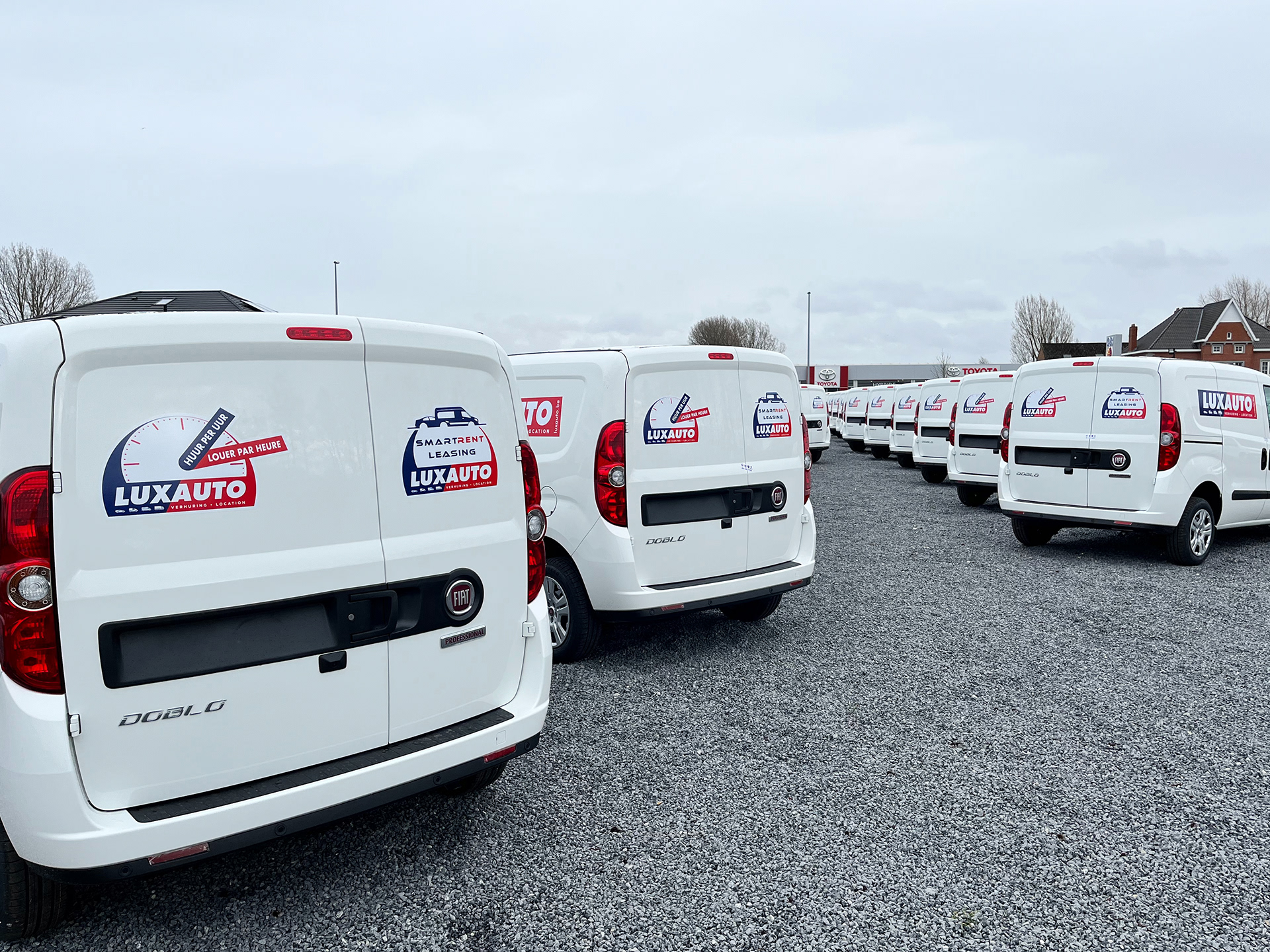 Overzicht van de Luxauto-bestelwagens, volledig buiten op locatie beletterd vlak voor de oplevering.