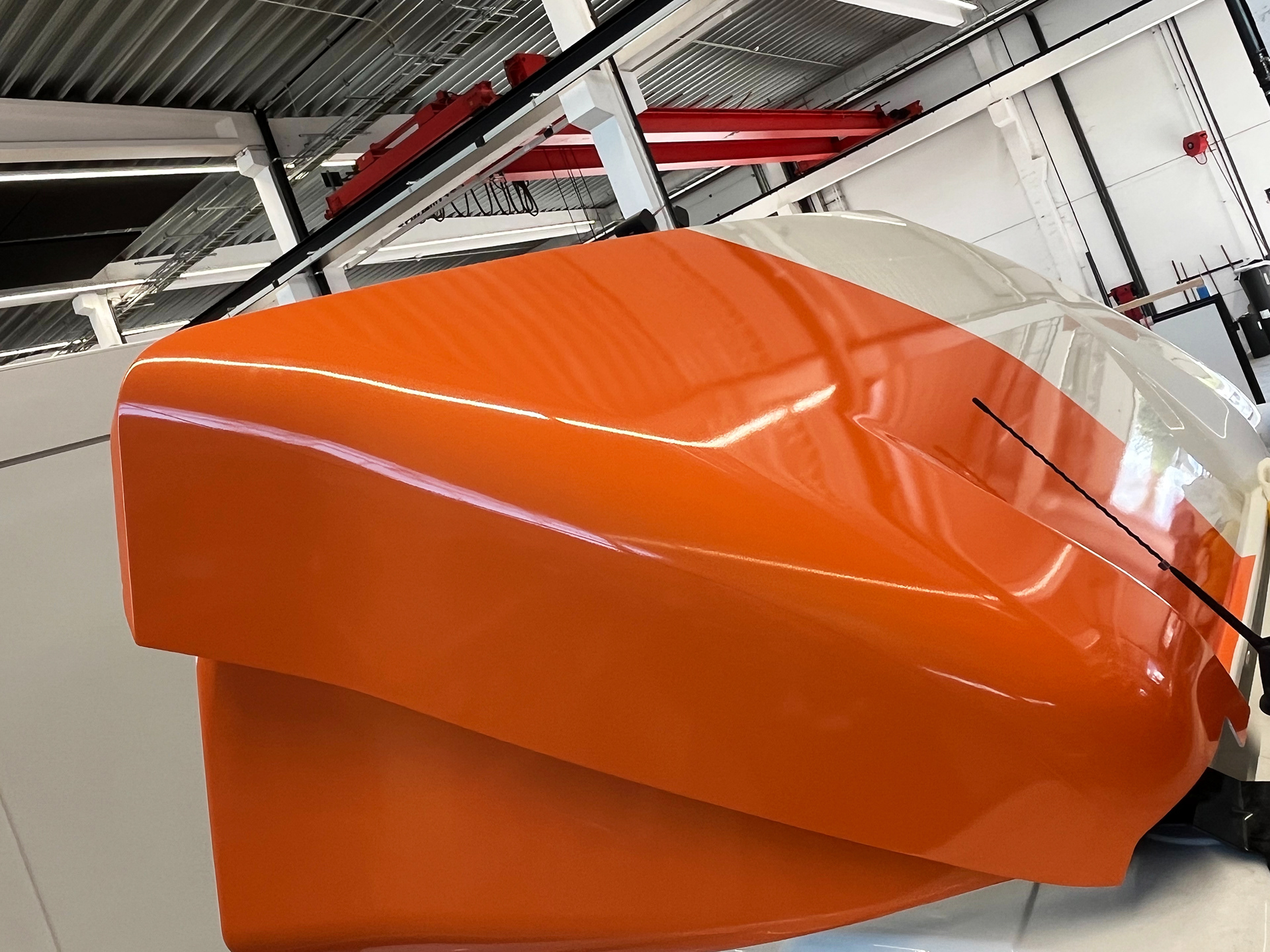 Complexe vormen, zoals deze aerodynamische spoiler, vragen om uiterste precisie en vakkundig maatwerk. Premium wrapping op locatie van XL-voertuigen te Bellegem (Kortrijk).