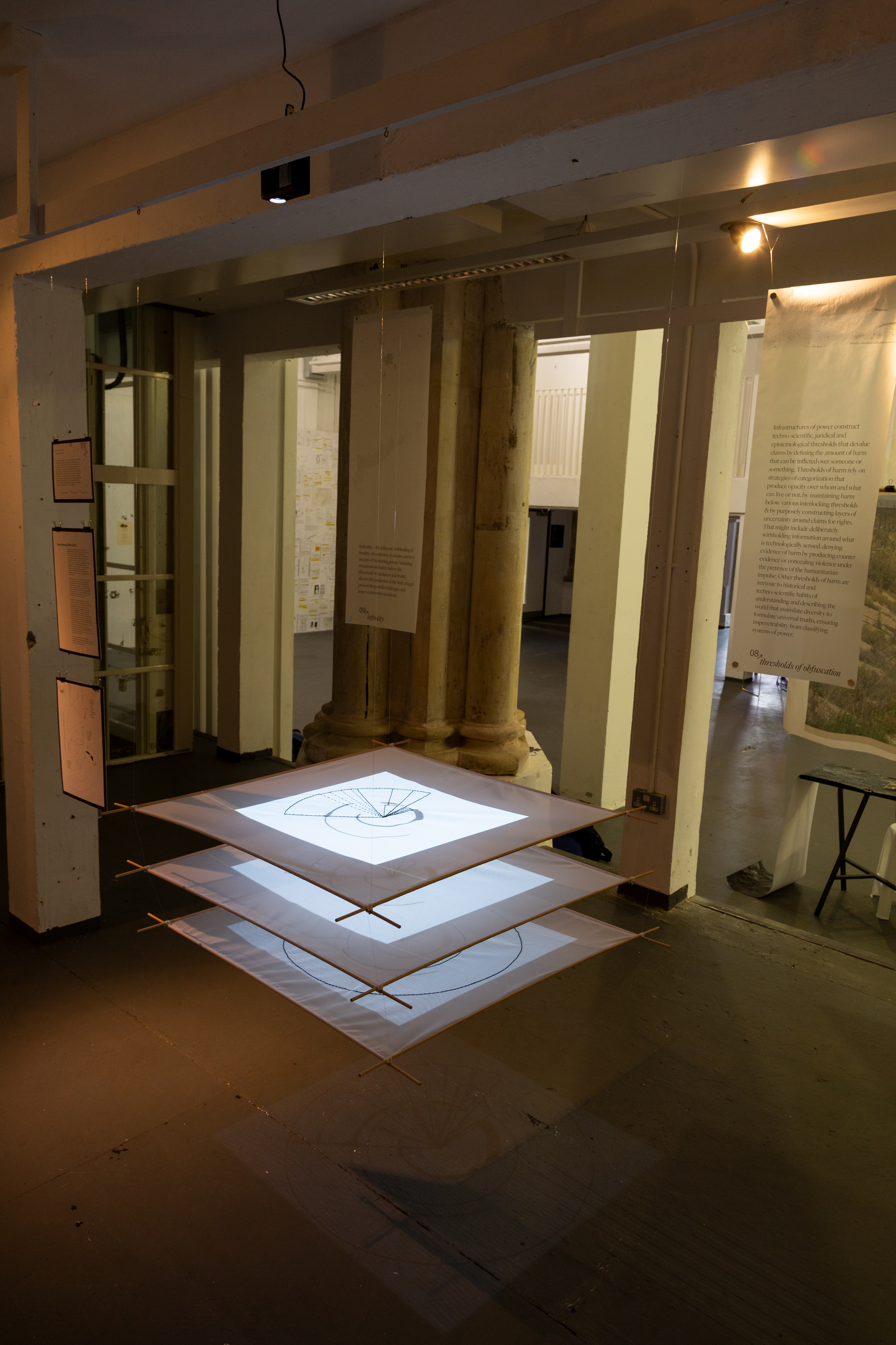 Exhibition of data visualization projected onto three sheer fabric panels. Photo Credit: Christa Holka