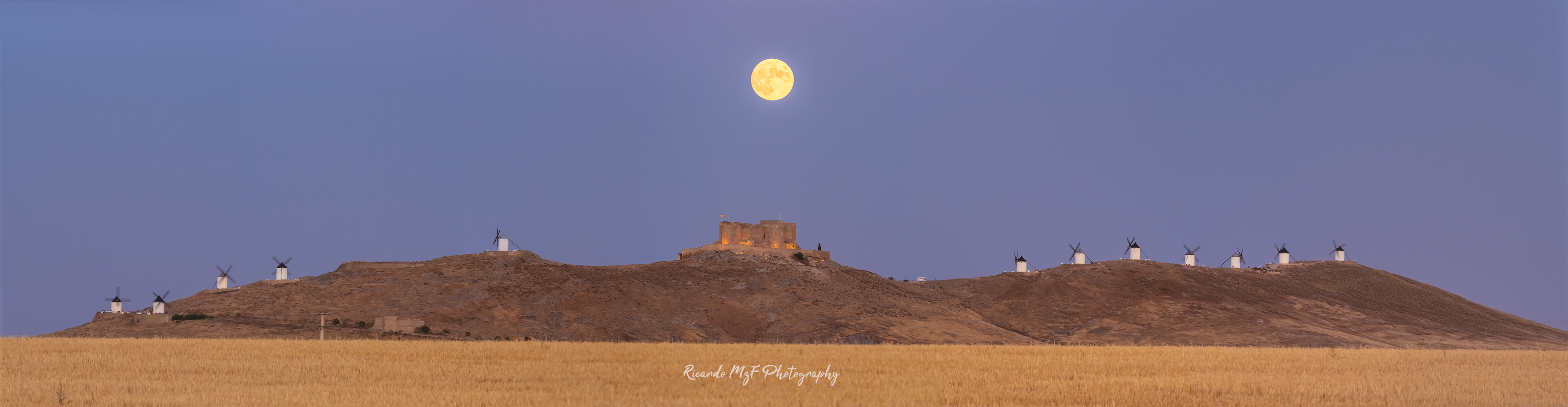 Panoramica salida de Luna sobre el castillo y molinos de consuegra