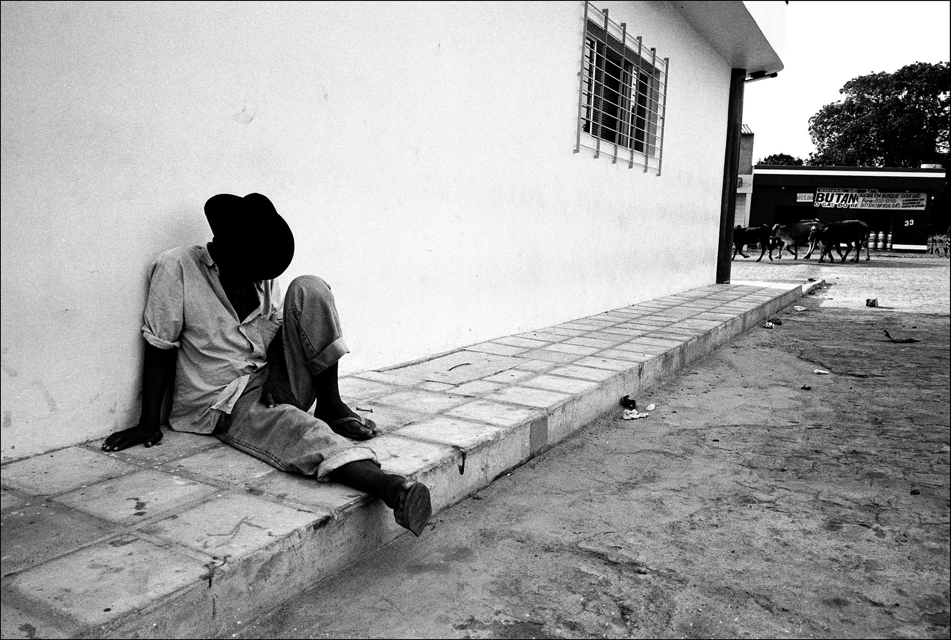 A man sits outside his home asleep. Galinhos is a small oceanside village in the far north of Brazil. Poised on a thin peninsular it can only be reached by a small fishing boat or by walking over the sand dunes that guard it from the mainland. The people make their living from the sea that surrounds them, and the few tourists that dare to venture. The village is however far from sleepy. After the boats come in the music is turned up, and the party starts, everyone loves to dance.  North West Brazil, August 1999