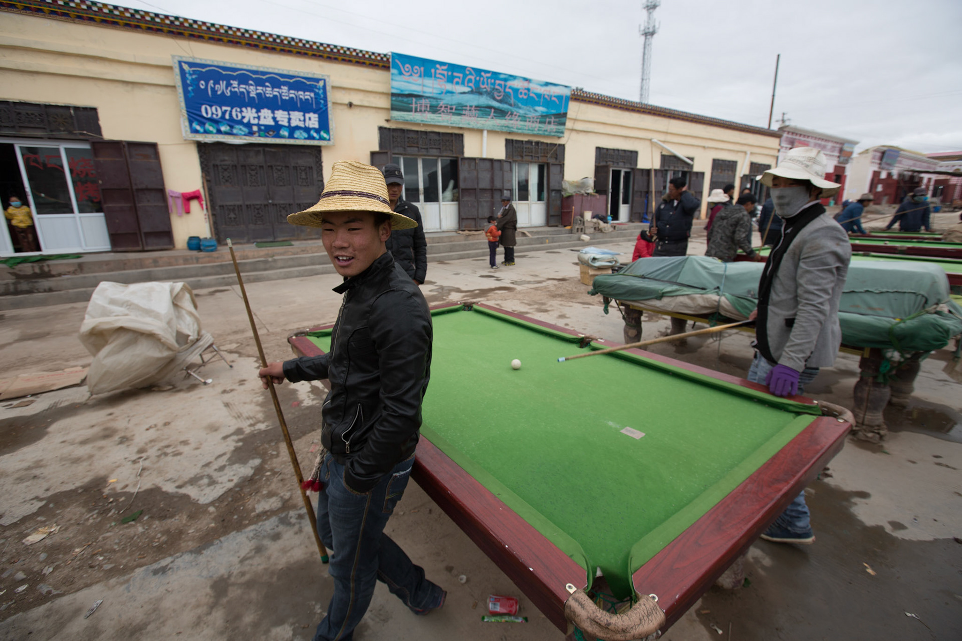 Pool tables outside in the streets of Qumalai.Ground temperatures have slowly risen in Qumalai county so a permanent frozen layer of soil just beneath the ground has melted away. The permafrost had acted to hold water near the surface allowing the grasslands to thrive but without it, the rain drains away leaving no water for the grass to feed on. The area is home to the sources of three of Asia’s great rivers, the Yangzi, the Yellow and the Mekong. Any ecological catastrophe here would affect hundreds of communities downstream. 06/09/2013, Qumalai, China.