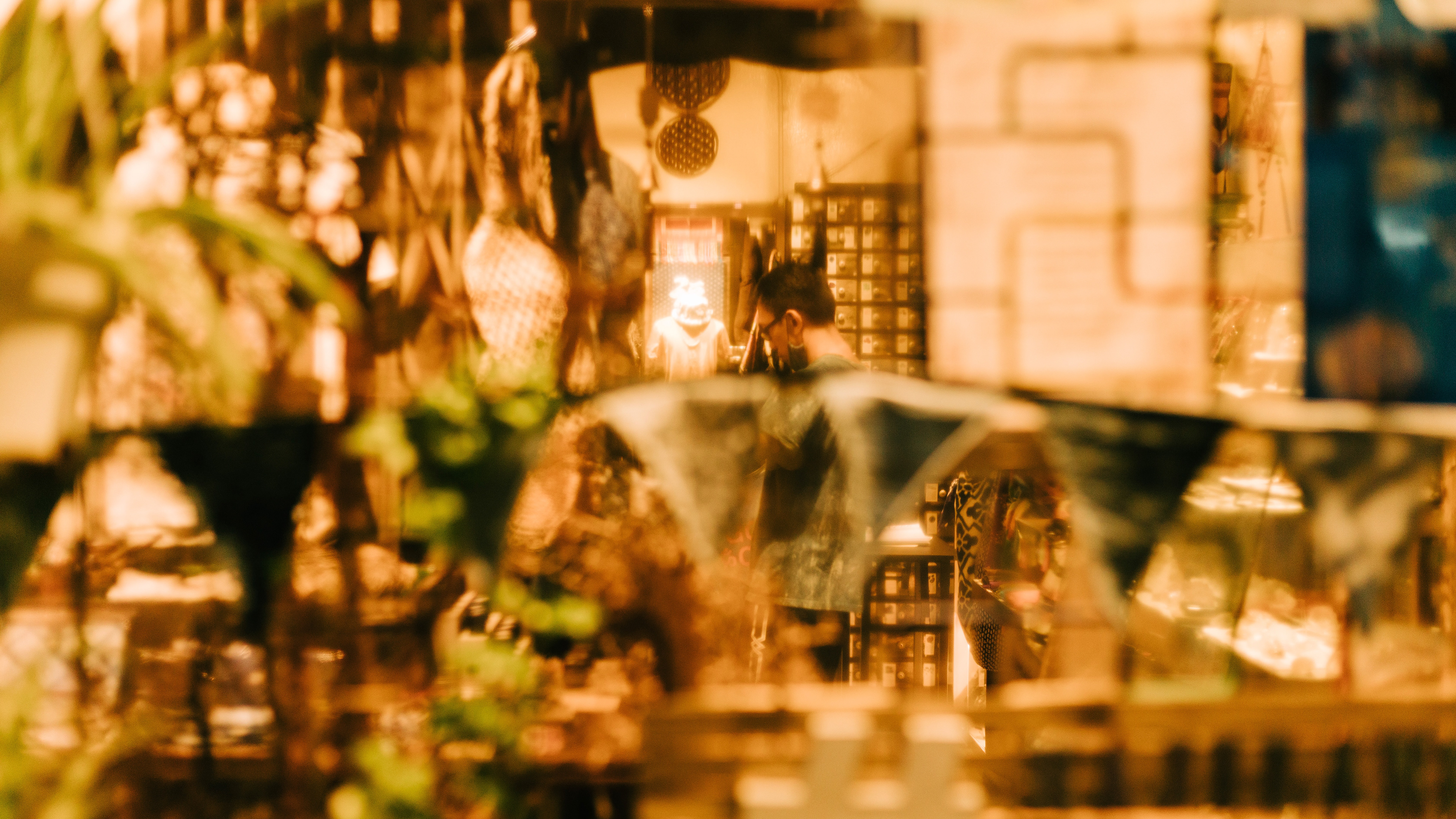 Cinematic unit-still capturing a layered shop window reflection in Singapore; low-light urban study in amber luminescence and voyeuristic perspective, exploring the mechanical soul of the city.
