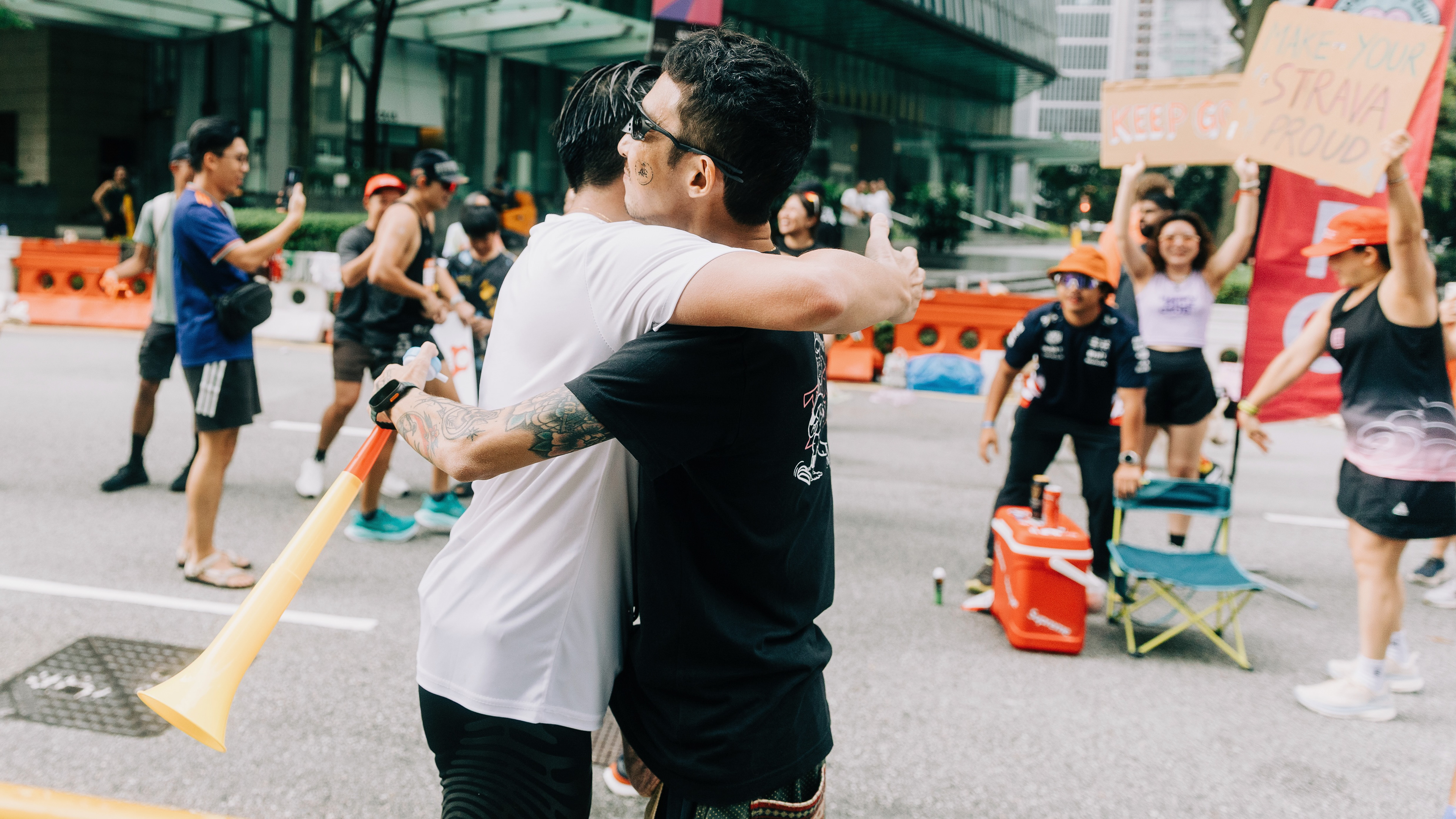 High-fidelity candid extraction documenting a raw emotional embrace during a large-scale urban event; selective focus on human connection within a high-stakes environment