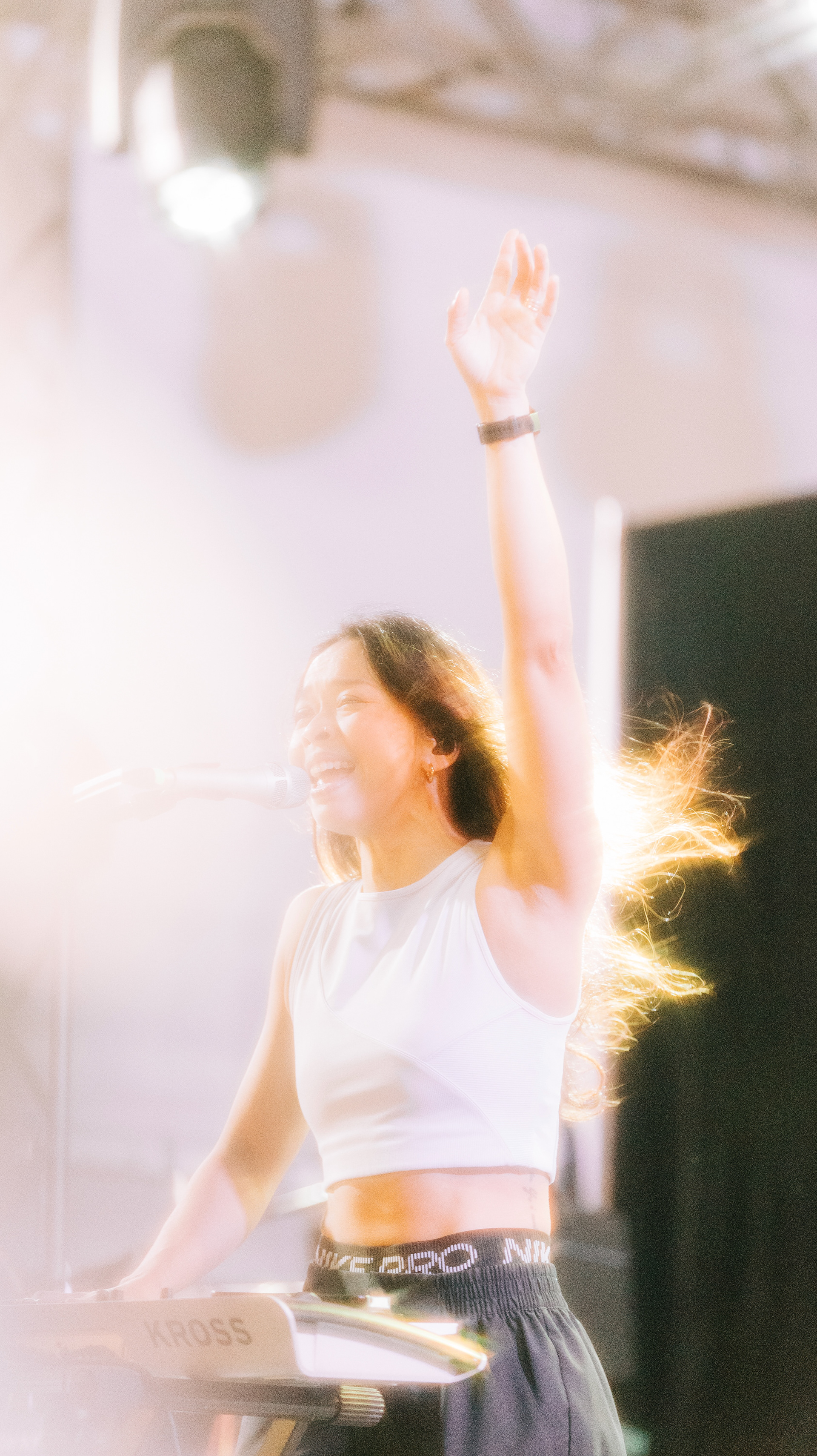 SA53 keyboardist and vocalist performing live on stage at GastroBeats Singapore with dramatic warm backlighting and motion flare.