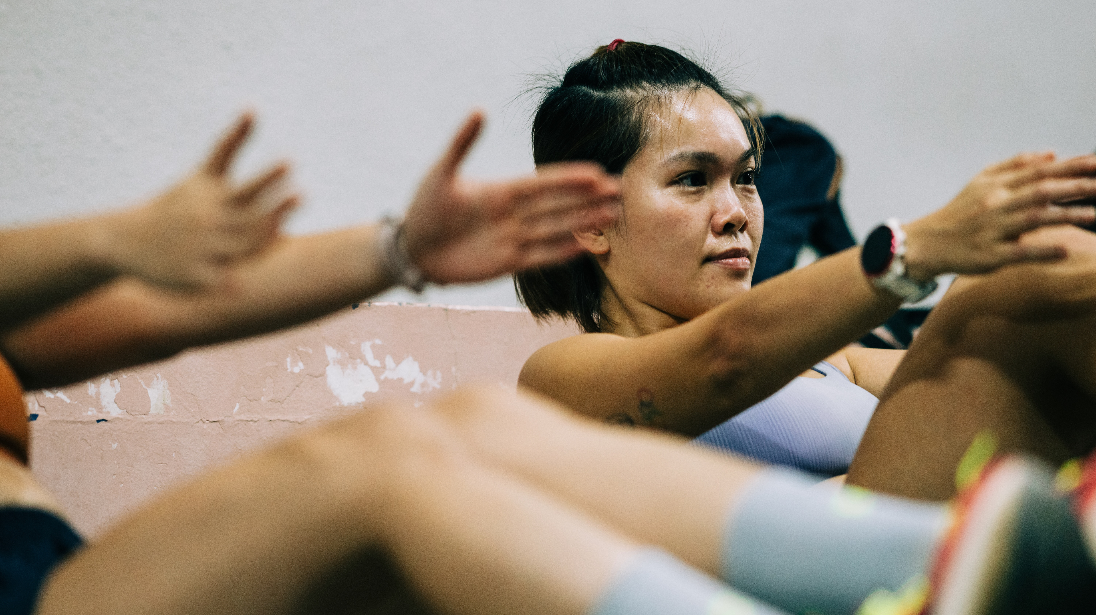 Natural light candid of an individual resting in athletic wear after effort, emphasizing the ease and grit of a community moment.