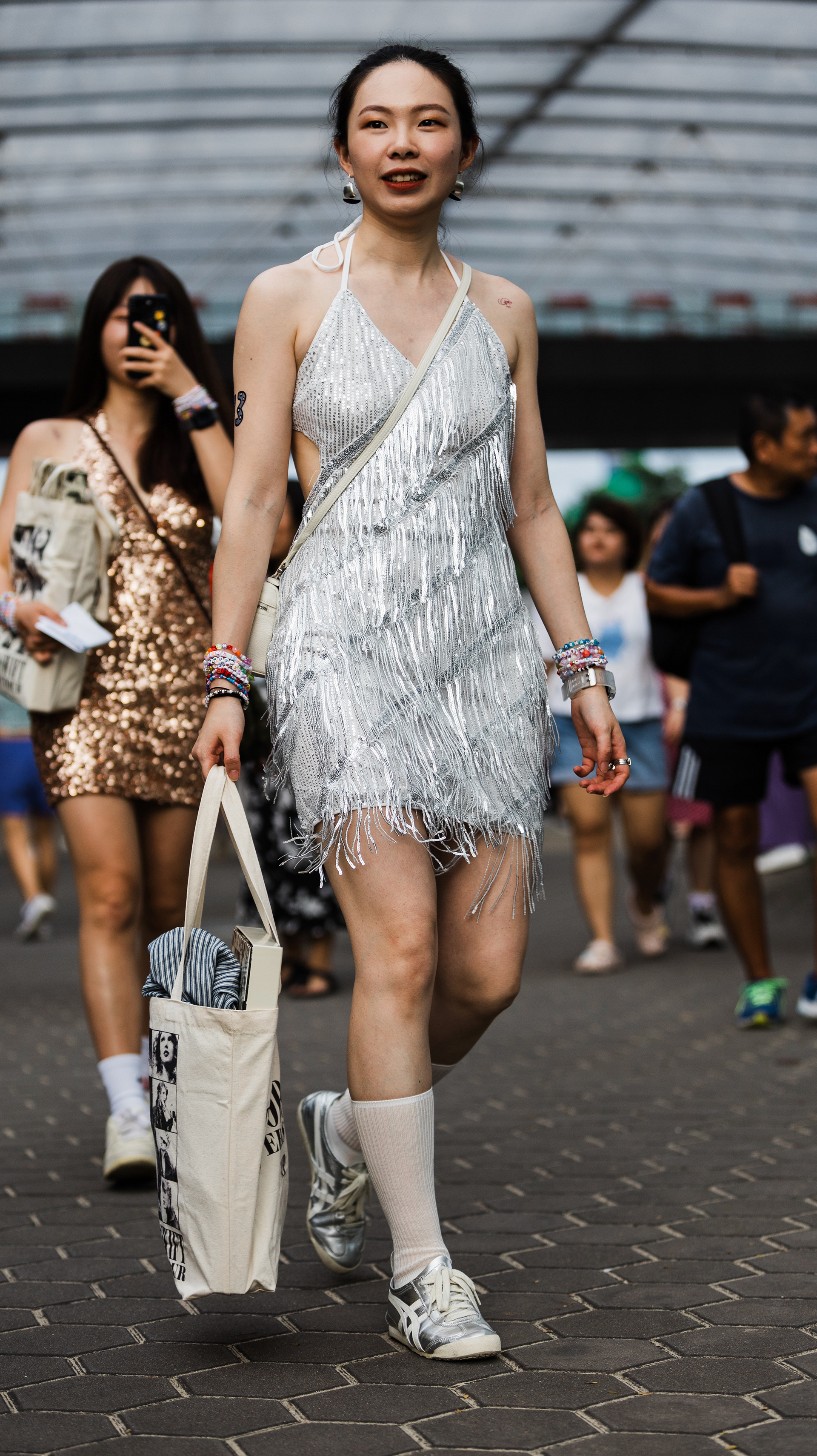 Observation of high-contrast concert persona. Analyzing the friction between vibrant participant color and the stark geometry of the modern transit labyrinth.