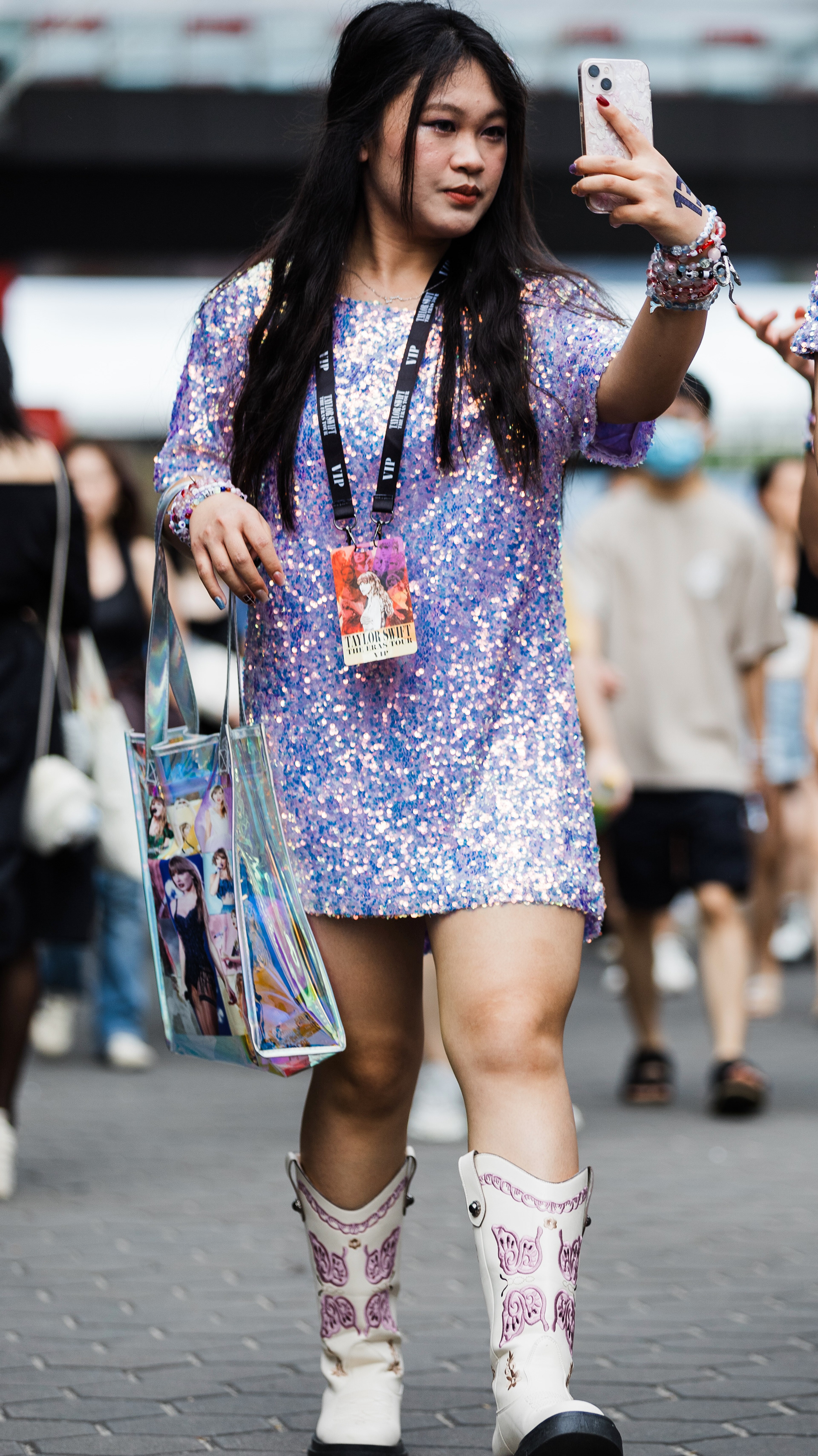 Quiet observation of a fan in 'Speak Now' purple, utilizing cinematic voyeurism to capture the specific textures of streetwear-inspired concert fashion. Part of the Persona: Eras archive.