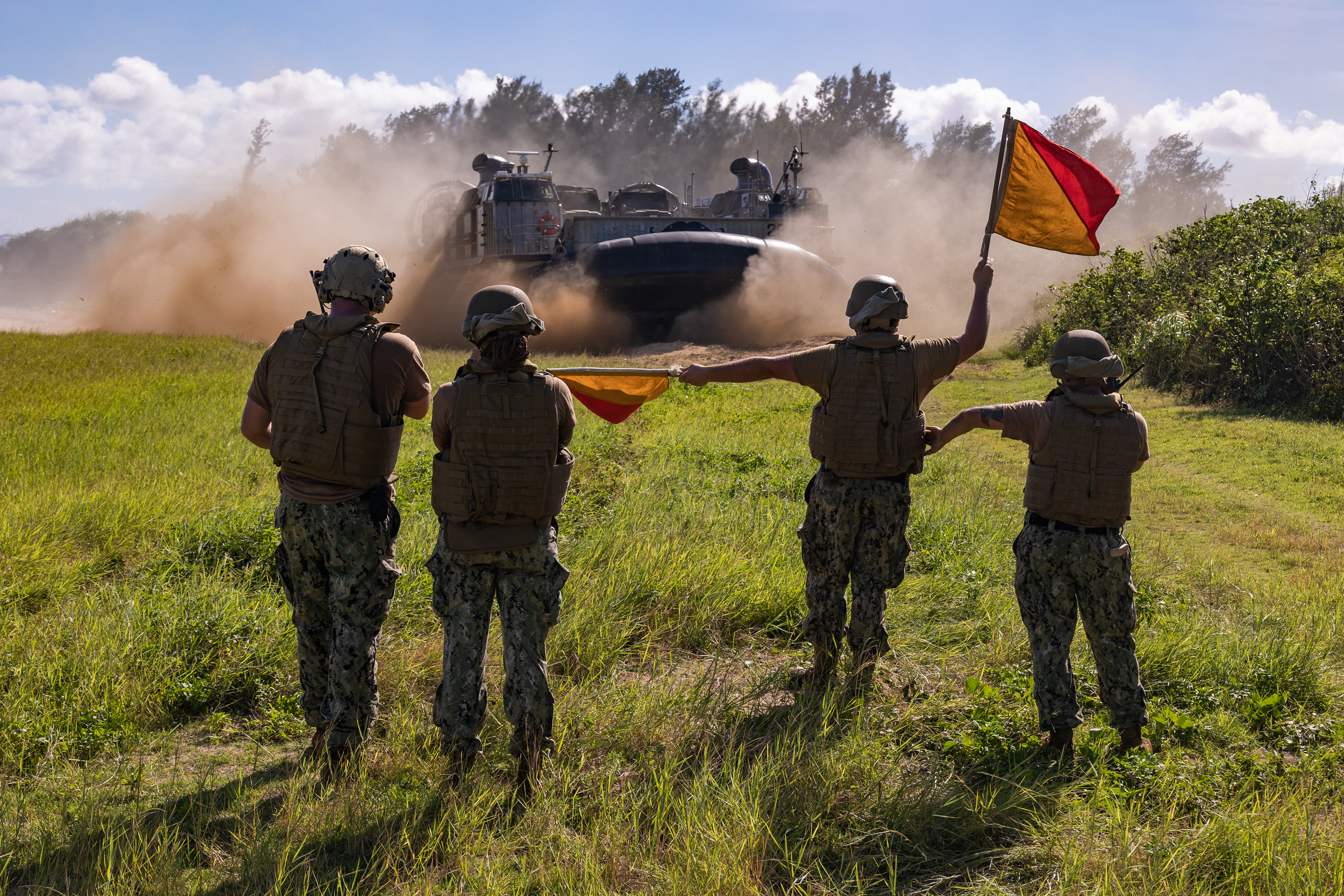 U.S. Navy Sailors assigned to the amphibious dock landing ship USS Comstock (LSD 45), direct a U.S. Navy landing craft, air cushion as U.S. Marines with Combat Logistics Battalion 31, 31st Marine Expeditionary Unit, arrive during an amphibious insert at Kin Blue Beach Training Area on July 29, 2024 in Okinawa, Japan.