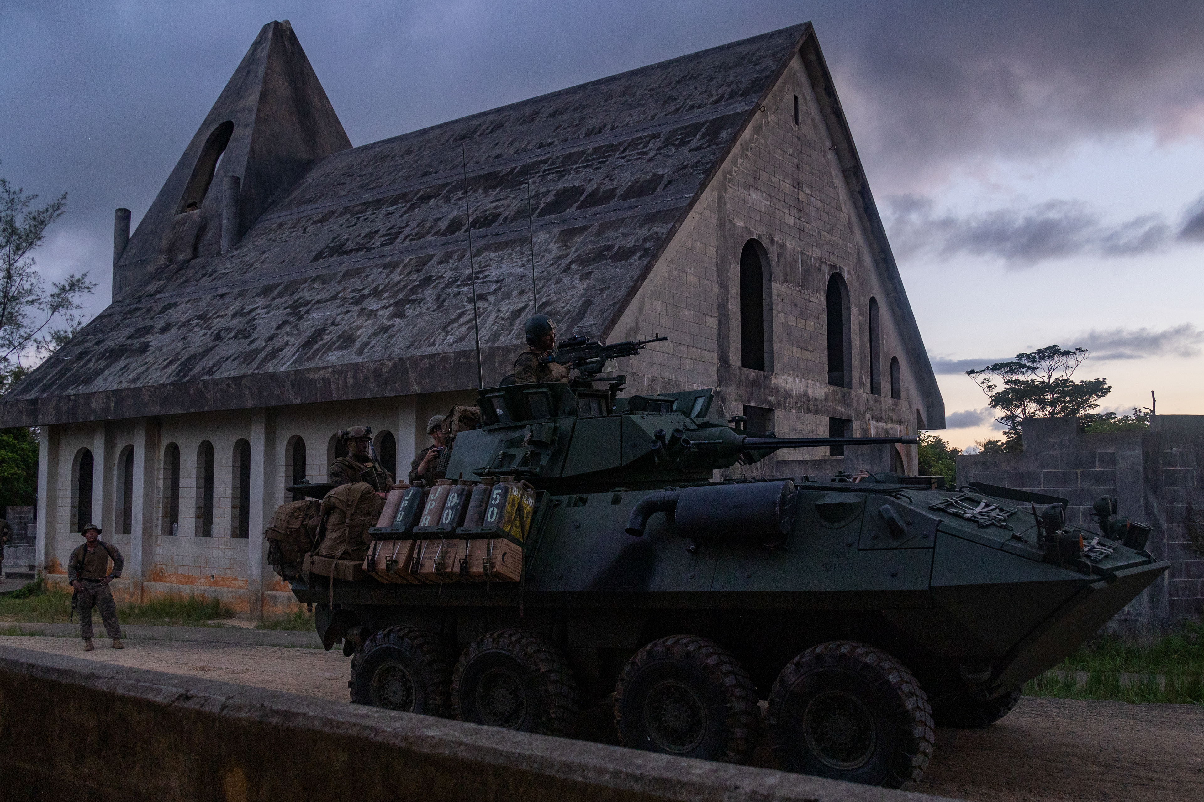 U.S. Marines with Battalion Landing Team 1/4, 31st Marine Expeditionary Unit, post security and provide return fire in a light armored vehicle during a simulated raid exercise on Combat Town at Camp Hansen on July 31, 2024 in Okinawa, Japan.
