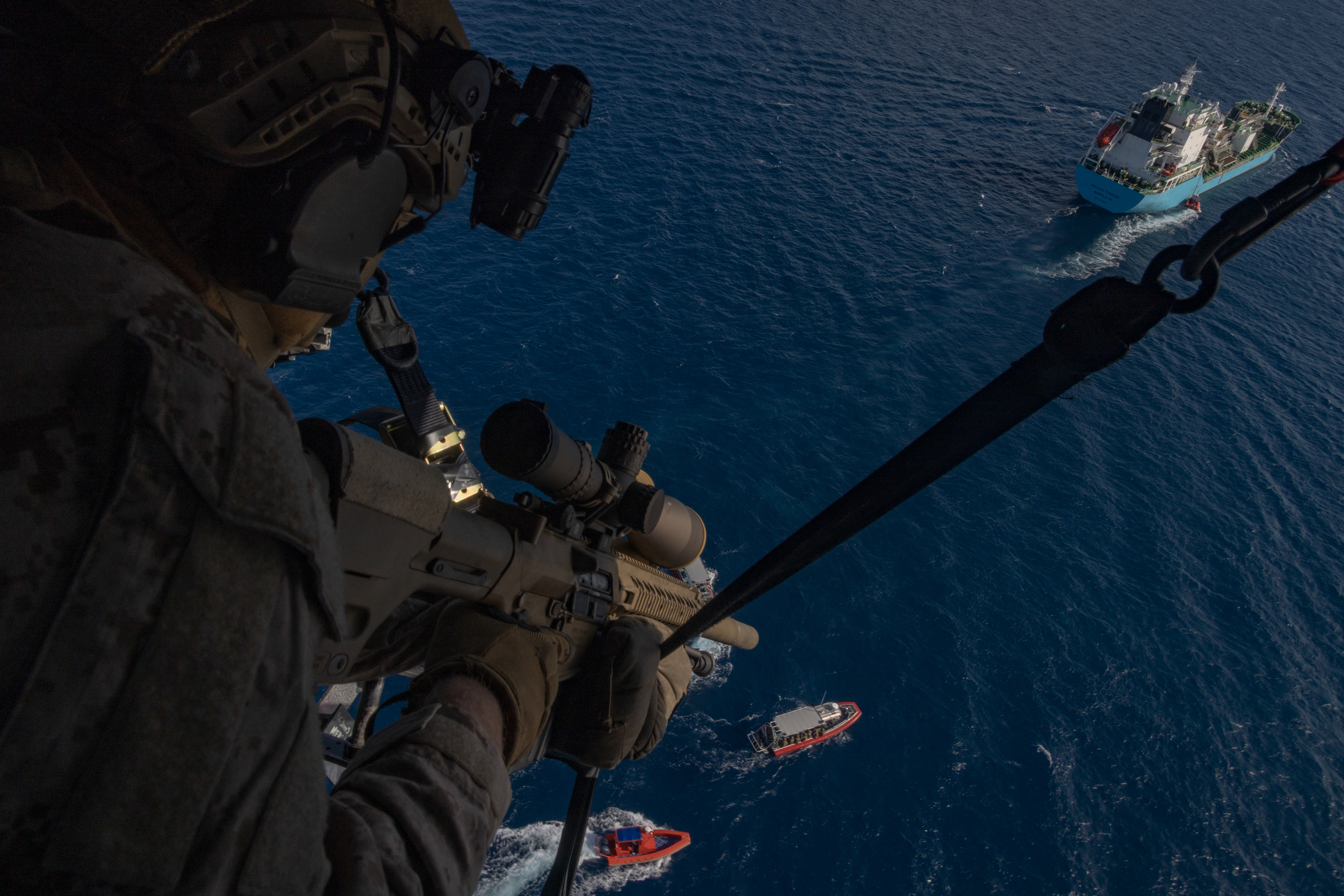 A U.S. Marine Corps sniper with Force Reconnaissance Platoon, Maritime Raid Force, 31st Marine Expeditionary Unit, sets security from a UH-1Y Venom helicopter assigned to Marine Medium Tiltrotor Squadron 262 (Rein.), during a visit, board, search and seizure exercise at White Beach Naval Facility on Dec. 12, 2024 in Okinawa, Japan.