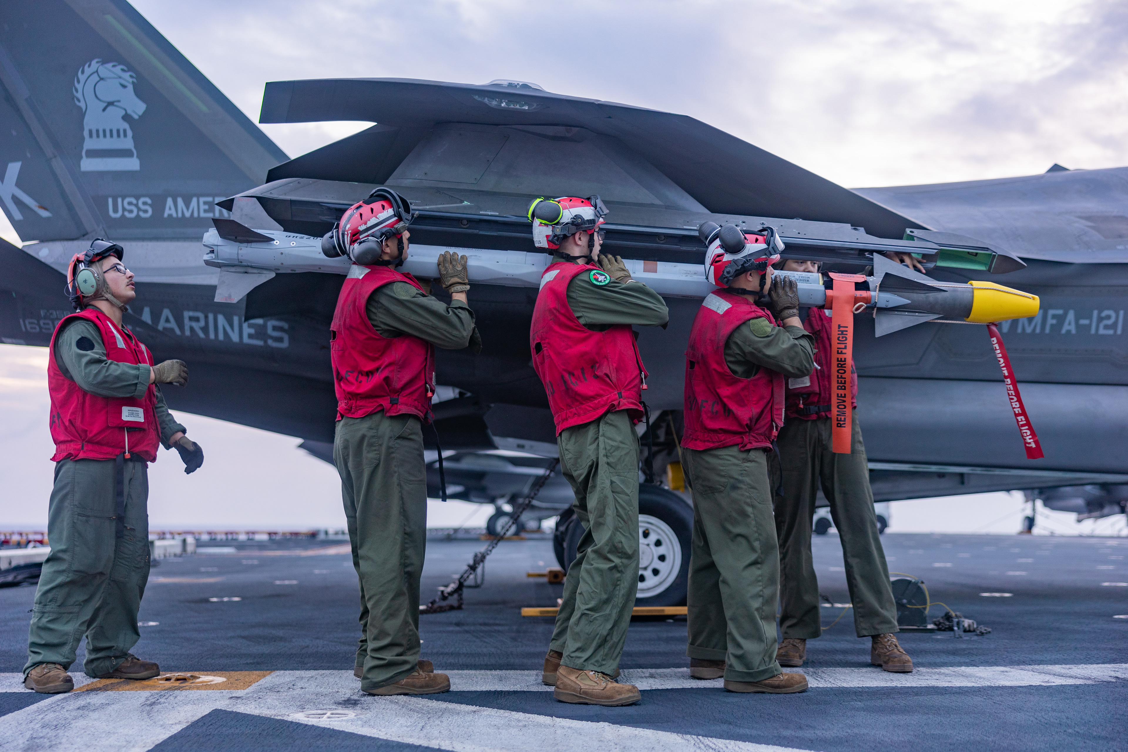 U.S. Marines with Marine Fighter Attack Squadron (VMFA) 121, 31st Marine Expeditionary Unit, load ordnance during F-35B Lightning II ordnance operations aboard the amphibious assault ship the USS America (LHA 6) on Aug. 21, 2024 in the vicinity of Miyako Strait.