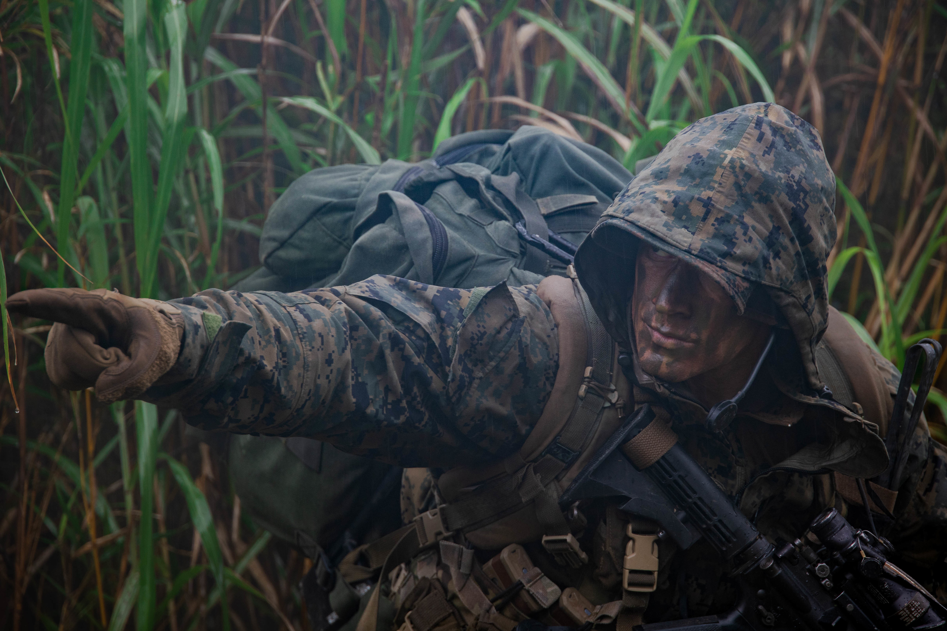 U.S. Marine Corps Sgt. Benjamin Thompson with Force Reconnaissance Battalion, III Marine Expeditionary Force, directs Marines during a patrol at Jungle Warfare Training Center on May 17, 2022 in Okinawa, Japan.