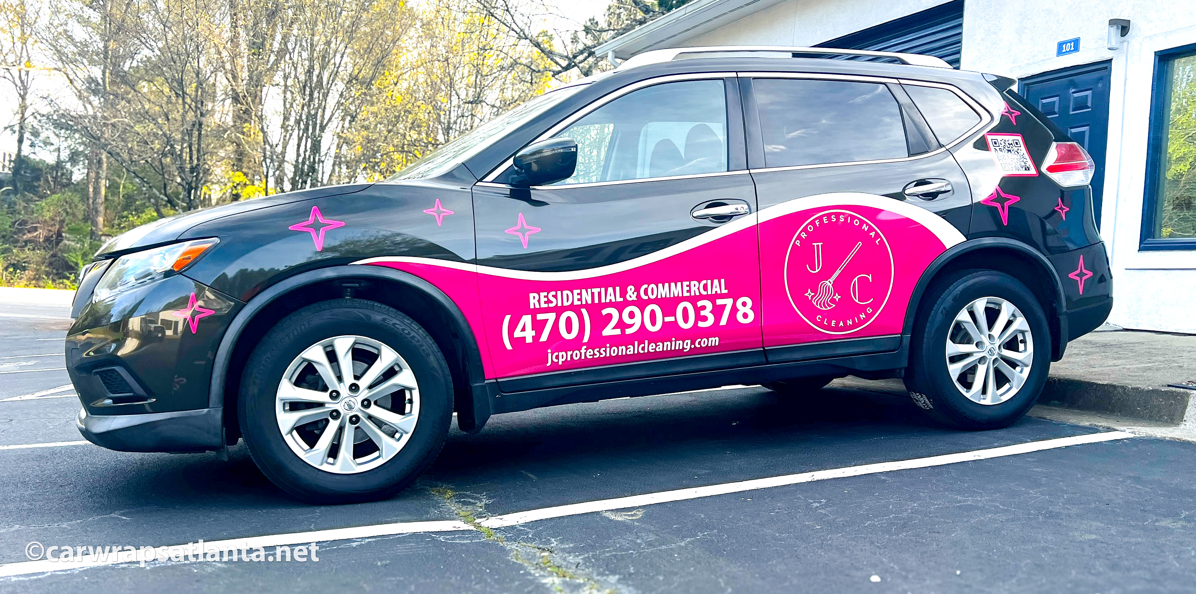 Close-up of the cleaning service logo and partial graphics on the side of the Nissan Rogue SUV.