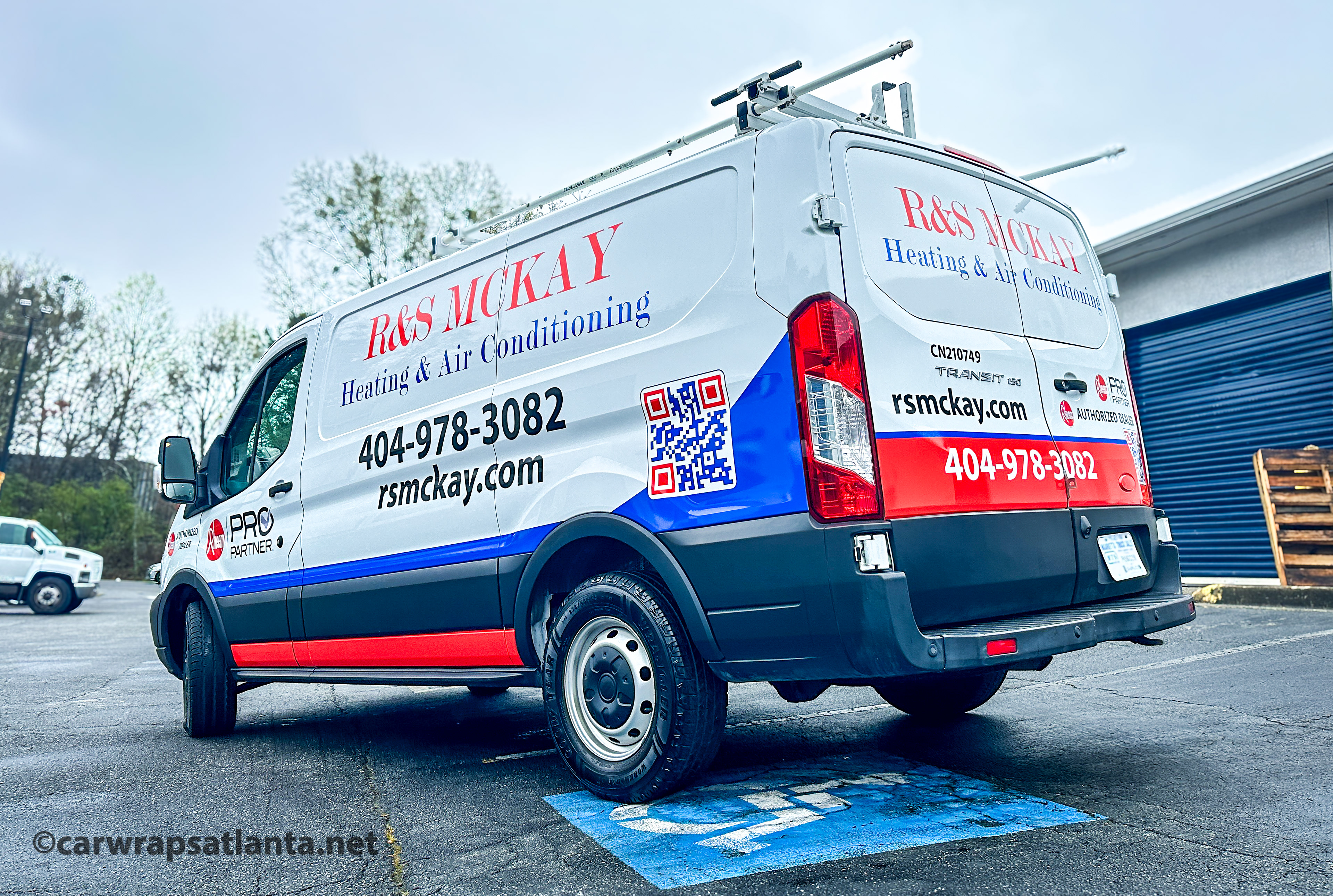 Close-up of the heating and cooling company's professional logo and partial graphics on the Ford Transit van.