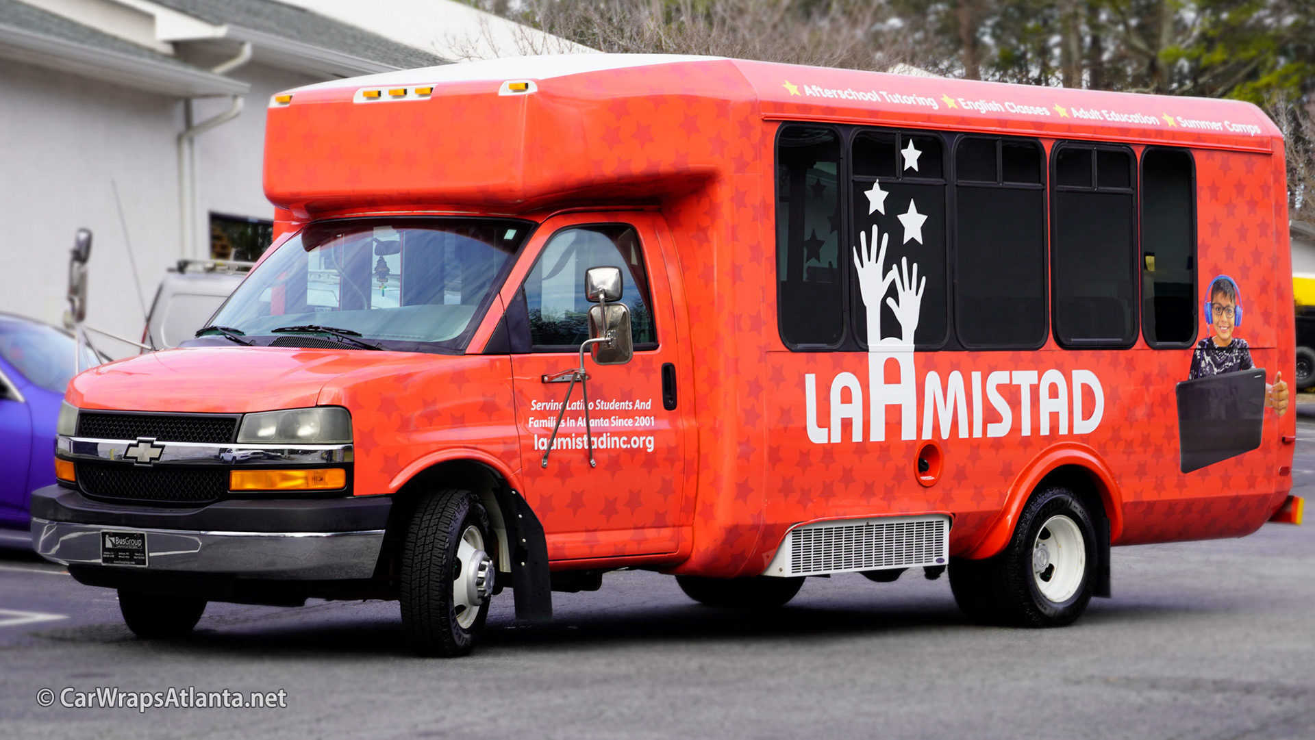 Close-up of La Amistad's logo and mission statement graphics on the durable full bus wrap vinyl.