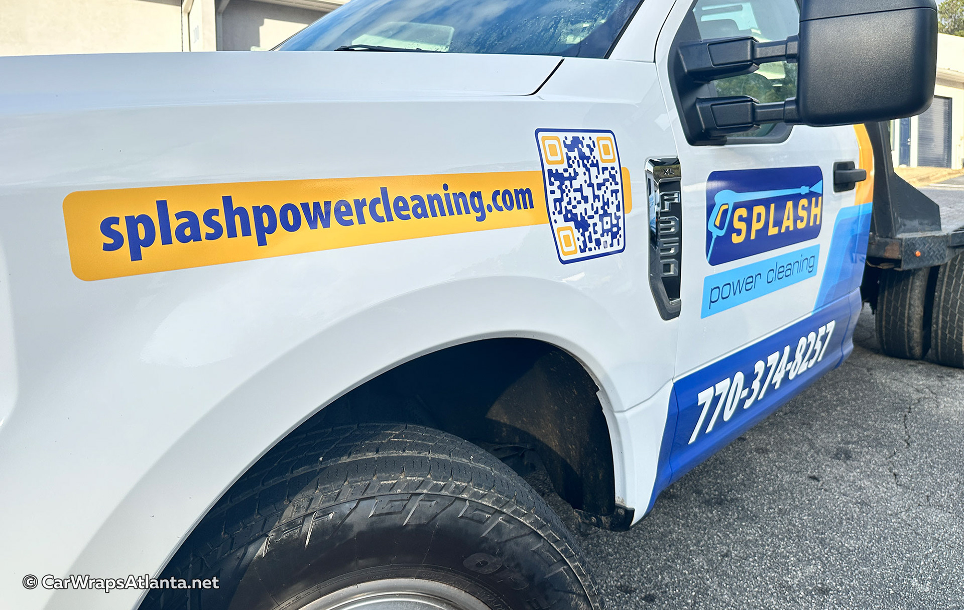 Close-up of vinyl fleet graphics featuring logo and contact info on an F-350 truck door