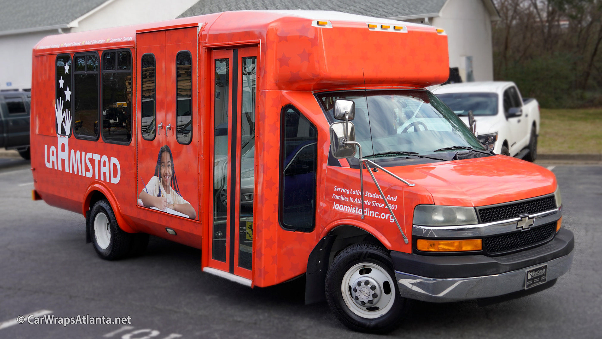 Full side view of the La Amistad bus wrap demonstrating the vibrant color and full coverage.