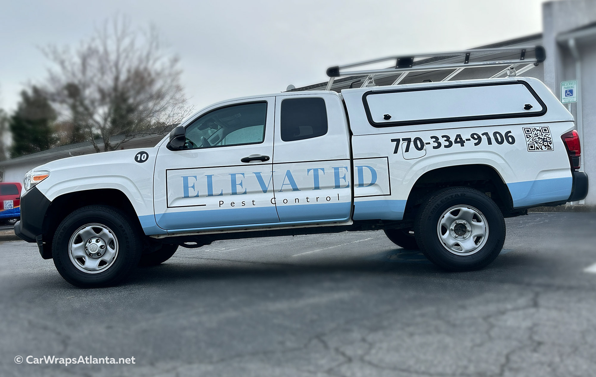 Professional spot graphics wrap on white Toyota Tacoma used for pest control services in Atlanta, GA.