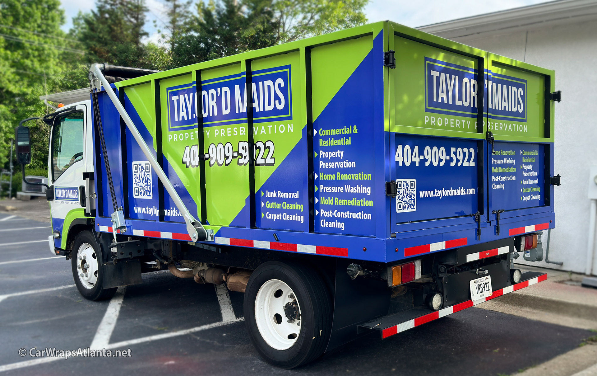 Rear view of the wrapped dump trailer emphasizing high-visibility contact information.