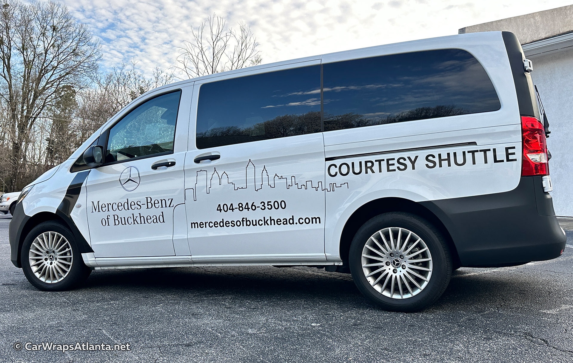 Professional vehicle graphics installation on Metris van showcasing premium spot graphics for shuttle service and fleet branding.