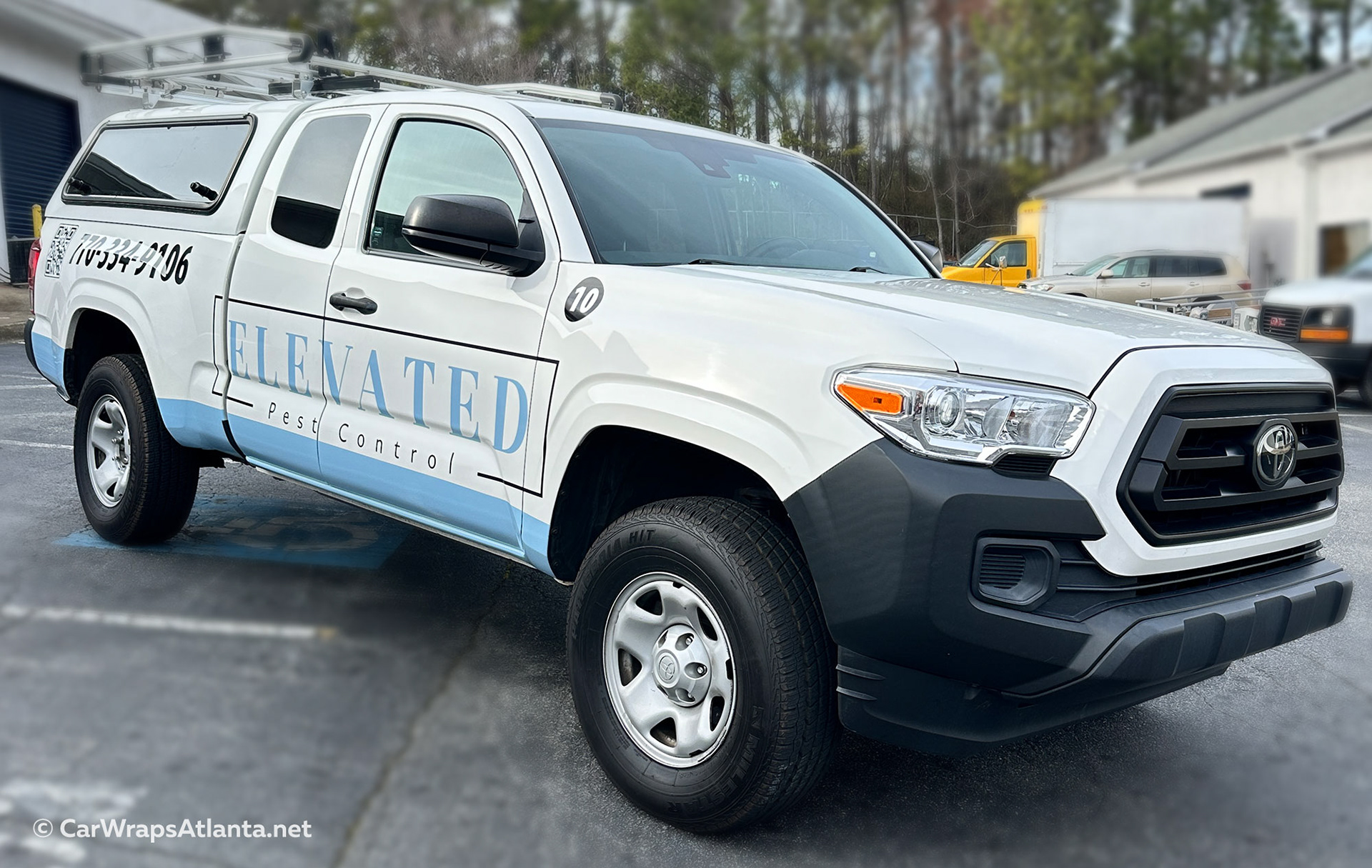 Atlanta pest control Toyota Tacoma with branded spot graphics, combining logo, pest imagery, and contact info in a clean vehicle wrap design.