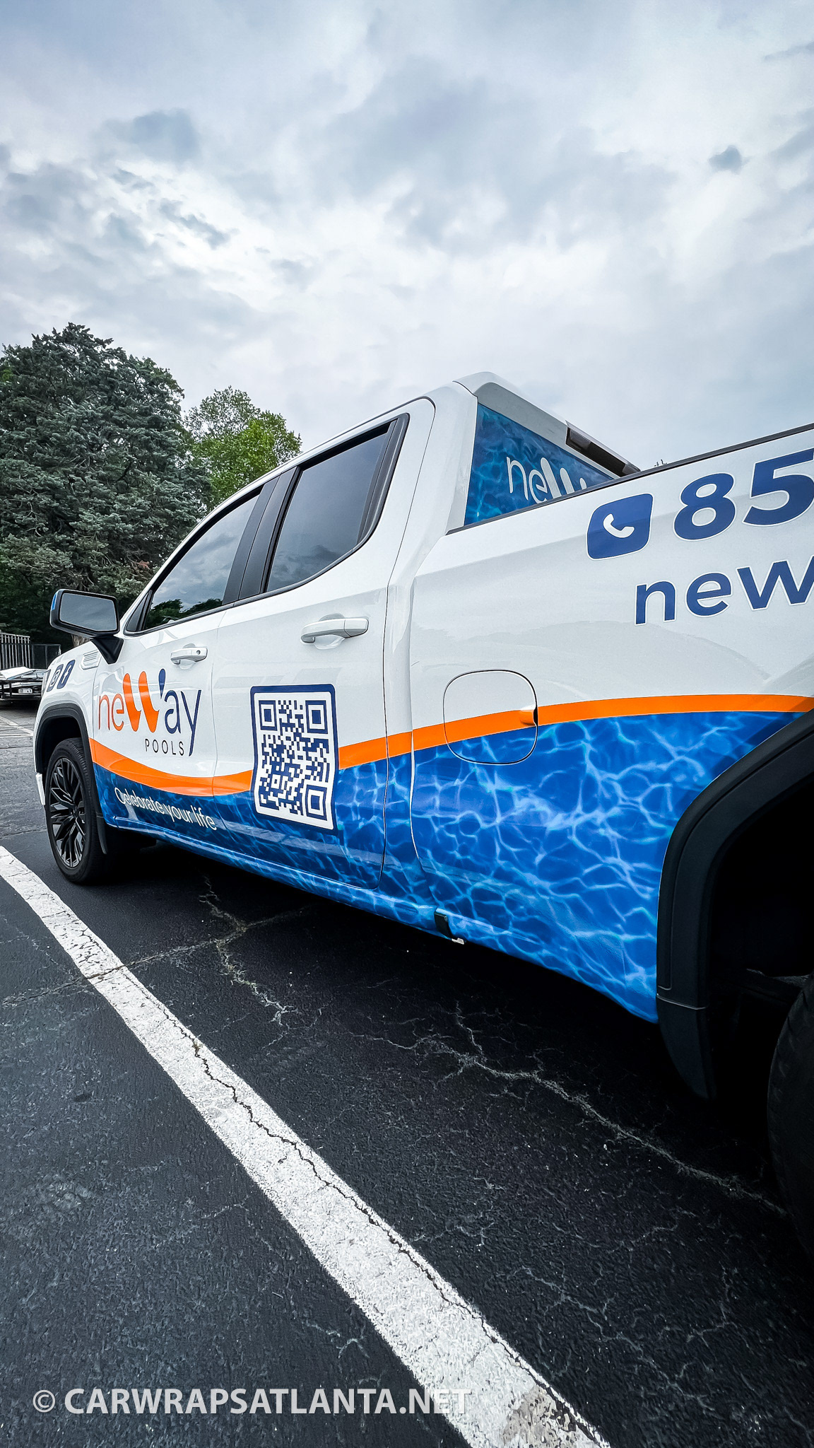 GMC truck with partial wrap demonstrating mobile advertising for pool construction services.