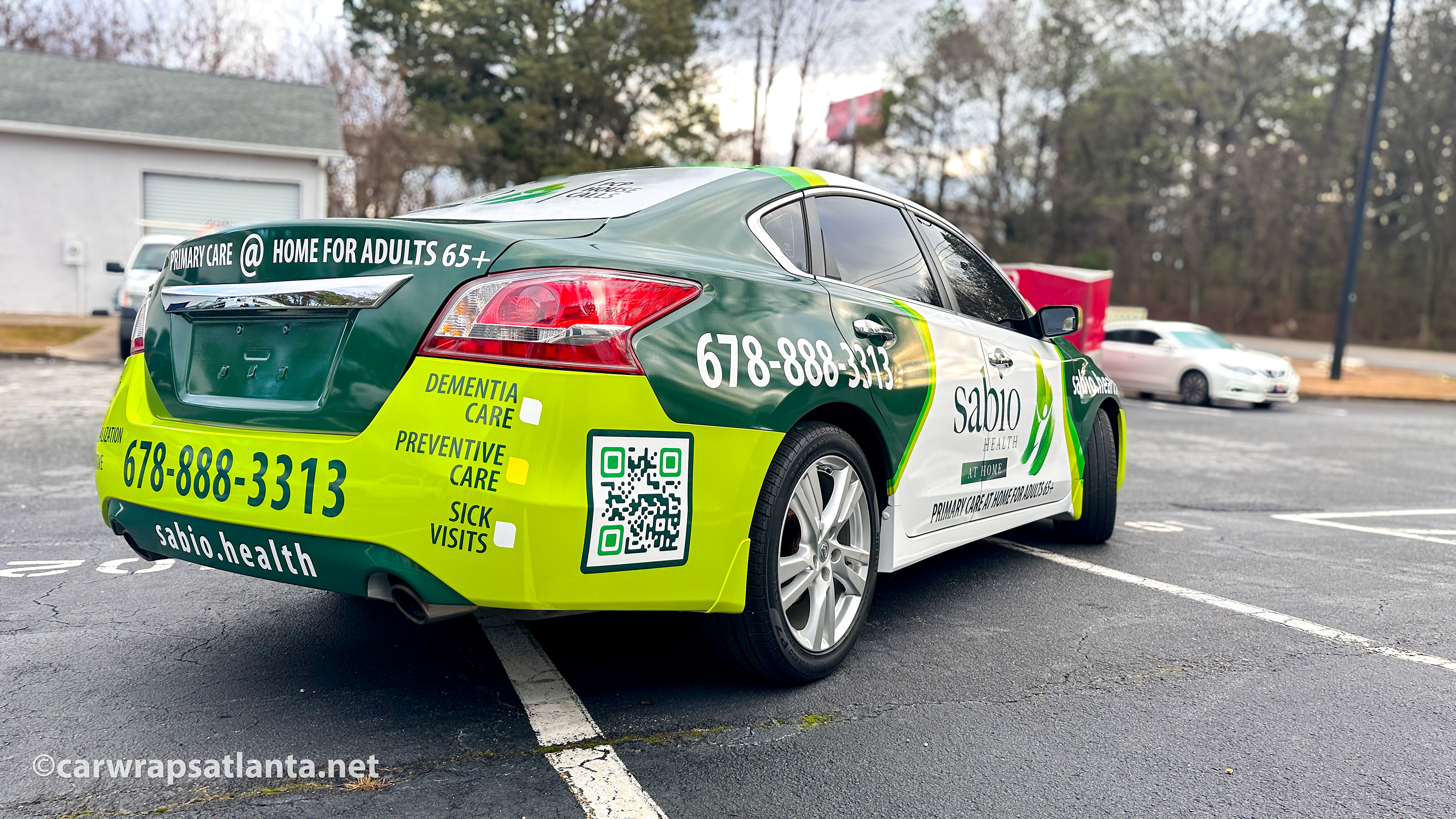 Rear view of a fully wrapped healthcare fleet vehicle displaying branding and emergency contact information in Atlanta.
