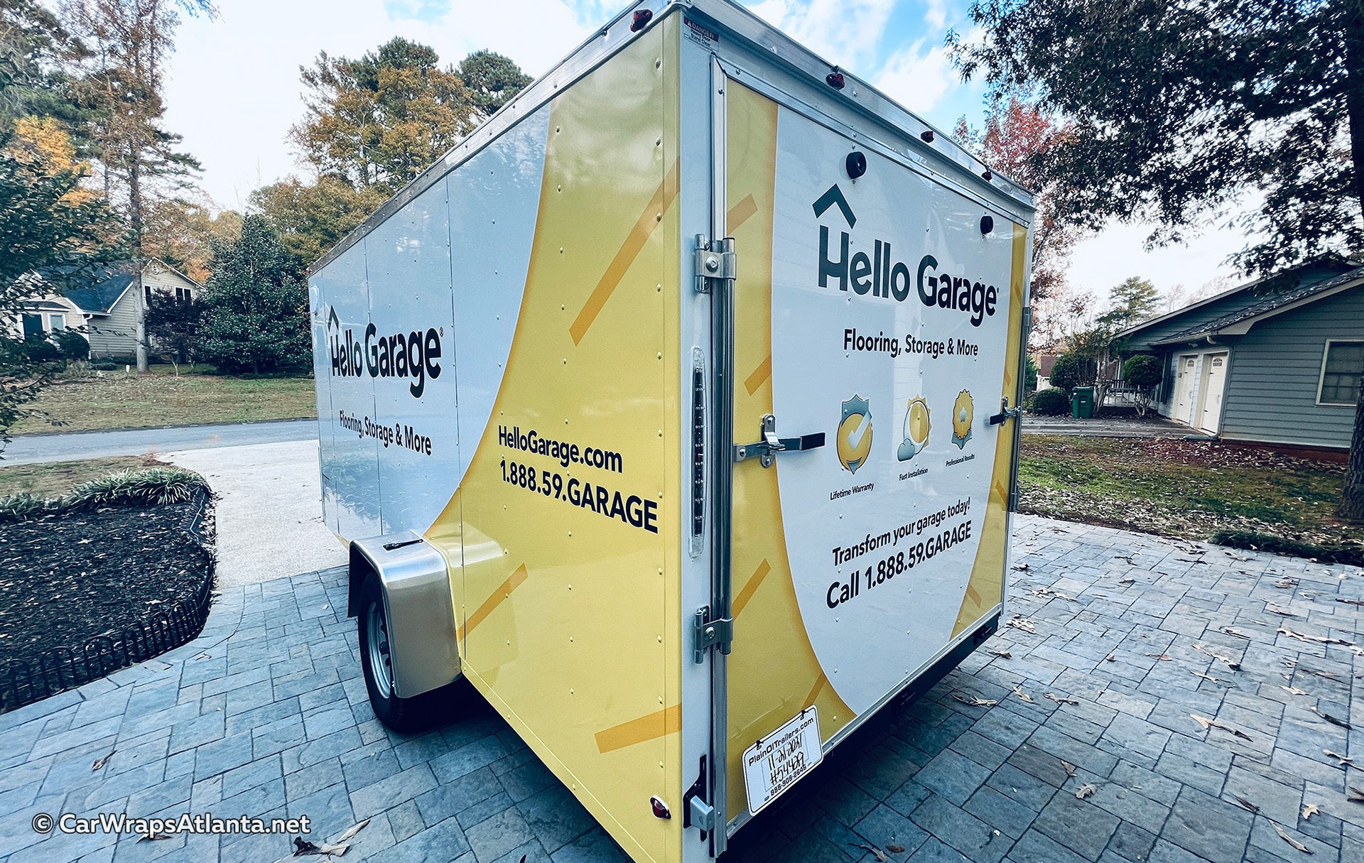 Full side view of the custom-wrapped Hello Garage trailer demonstrating brand consistency.