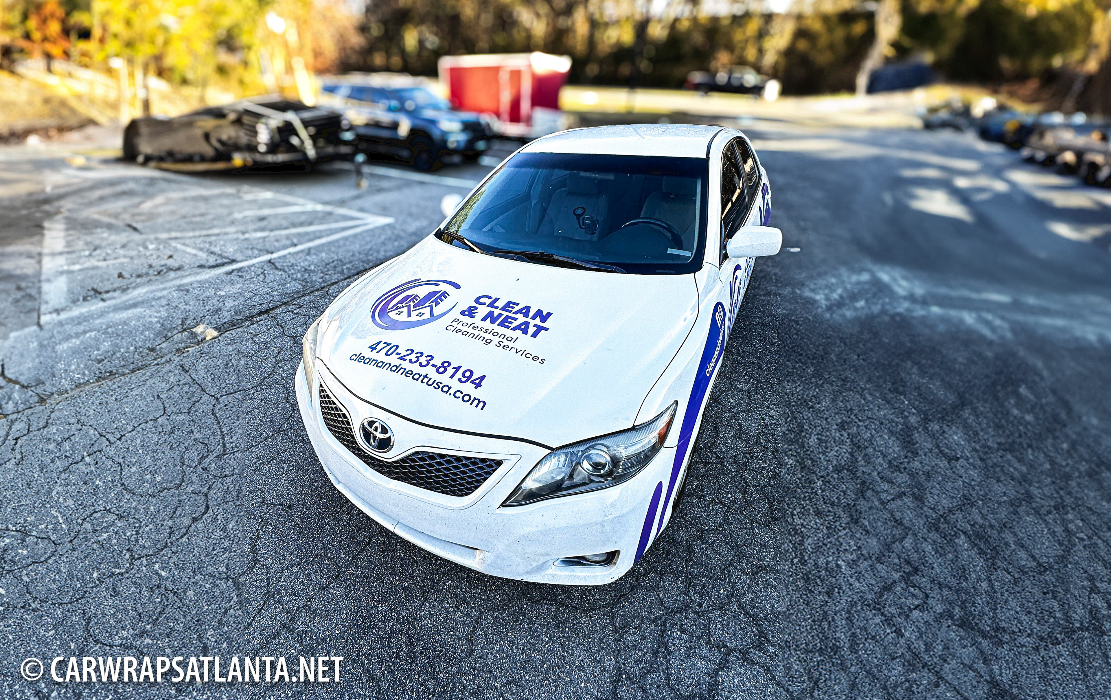 Toyota Camry with partial wrap parked in an Atlanta residential area, highlighting cleaning service visibility.