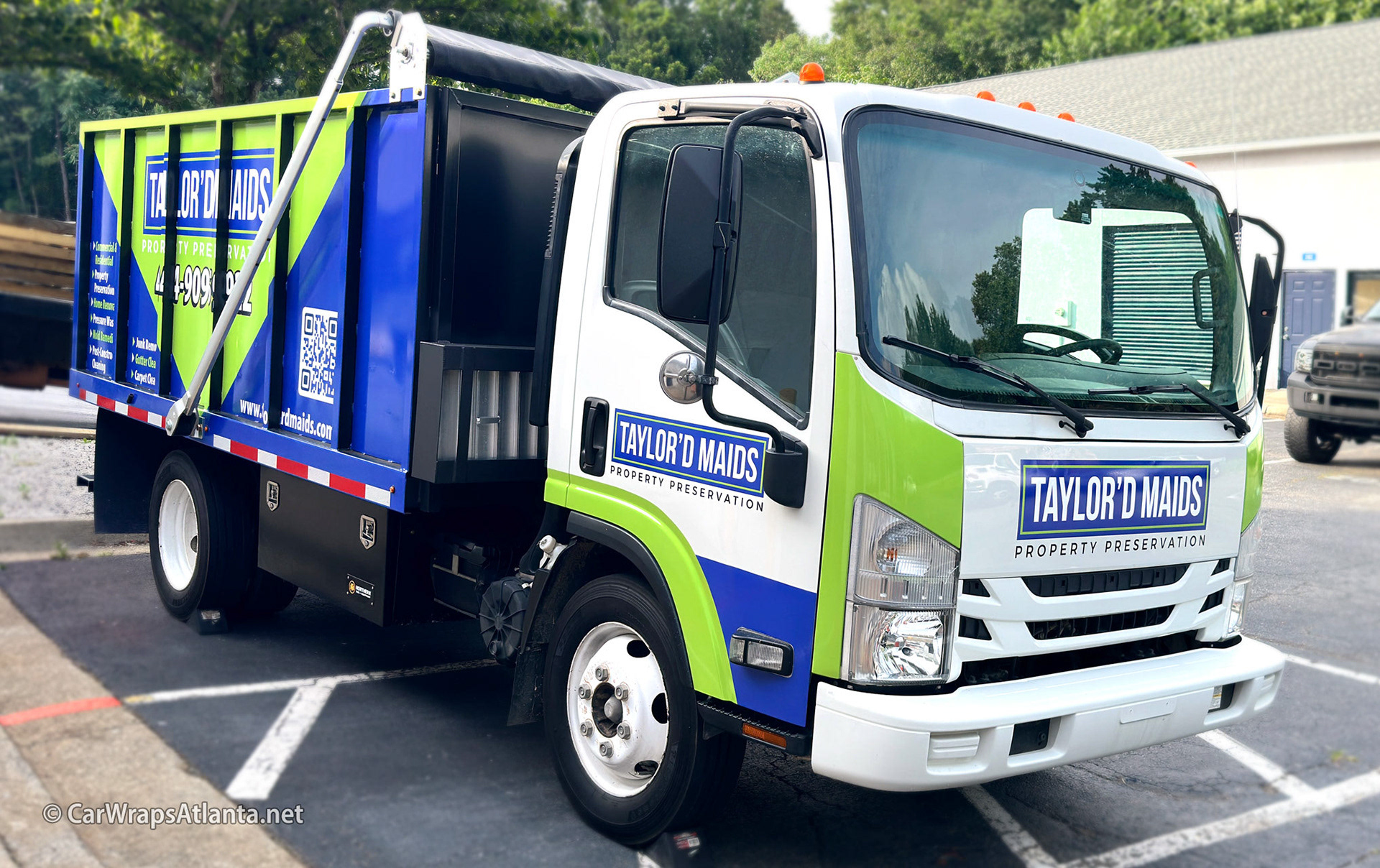 Close-up of the Tailor D Maids logo and branding graphics on the Isuzu Dump Trailer wrap.