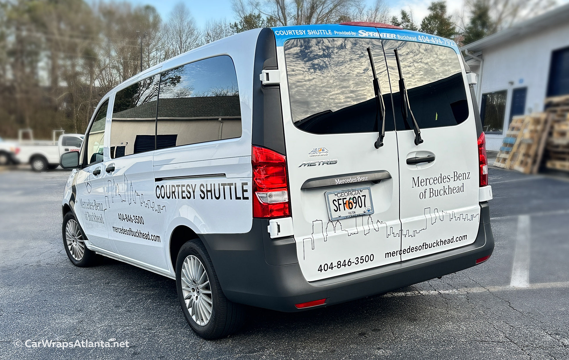 Custom spot graphics and vinyl decals on Mercedes-Benz shuttle van as part of high-impact fleet wrap design for dealership visibility.