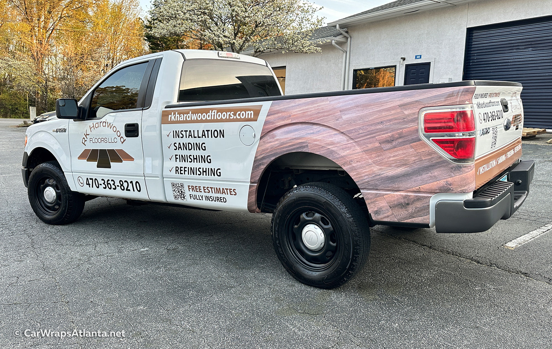 Atlanta-based business truck featuring partial vinyl wrap with flooring company logo and contact