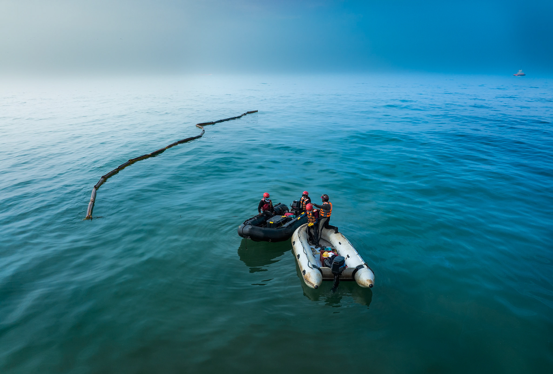 Aerial view of cleanup efforts after oil spill at "La Pampilla" refinery, Ancon, Lima, Peru on 2022. Workers in protective suits cleaning a sand beach on the shoreline.
