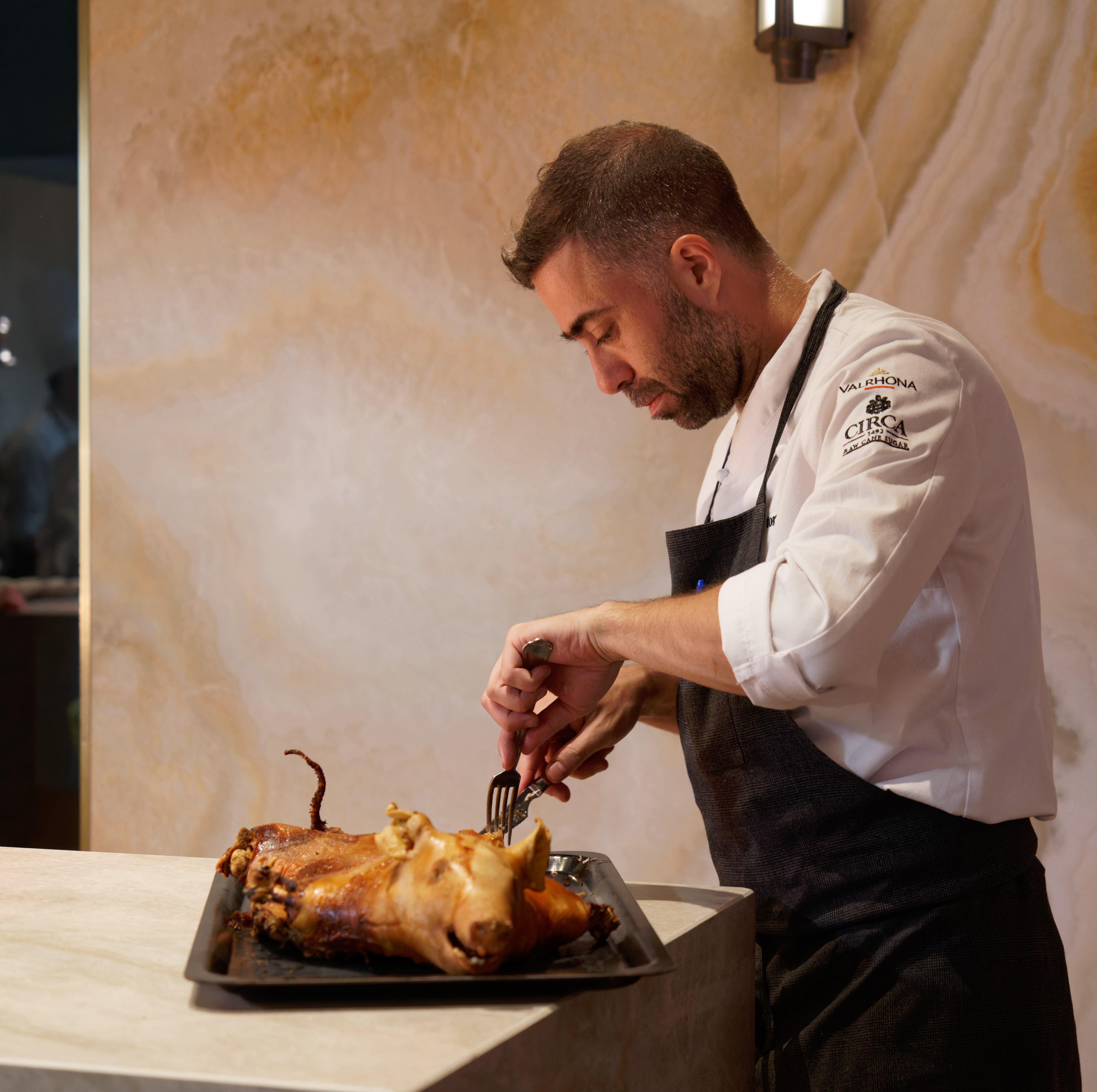 Diego Gavira, jefe de cocina, cortando el cochinillo