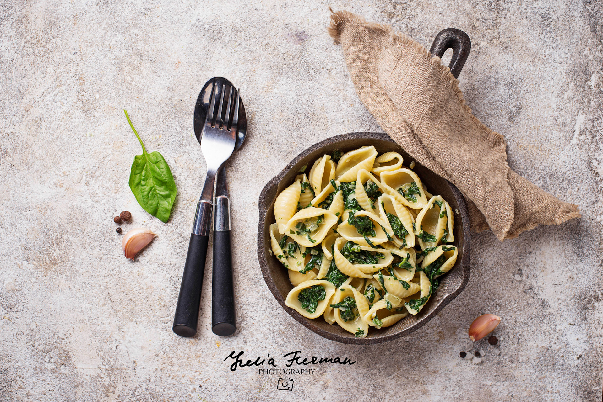 Conchiglioni pasta with spinach in creamy sauce. Top view