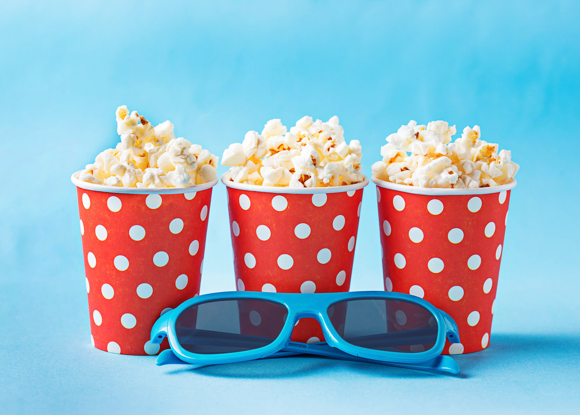 Popcorn with 3d glasses on blue background. Selective focus