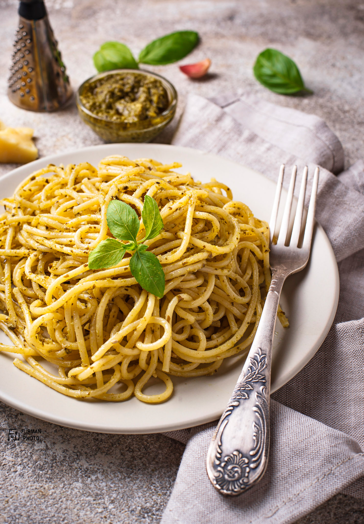 Italian spaghetti pasta with pesto sauce on grey background