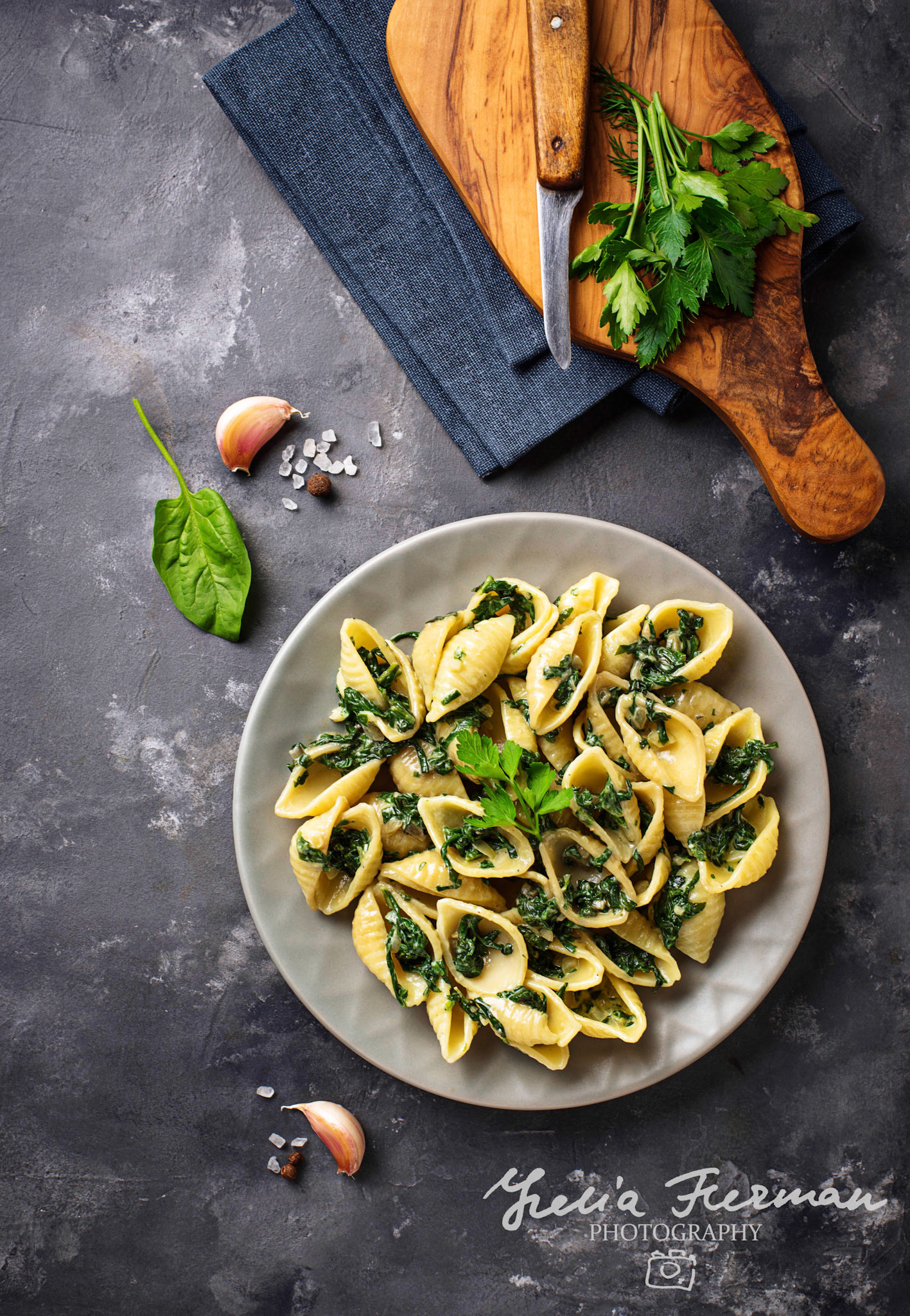 Conchiglioni pasta with spinach in creamy sauce. Top view