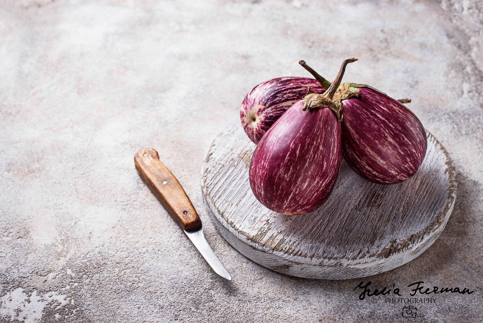 Fresh striped purple aubergines on light background. Selective focus