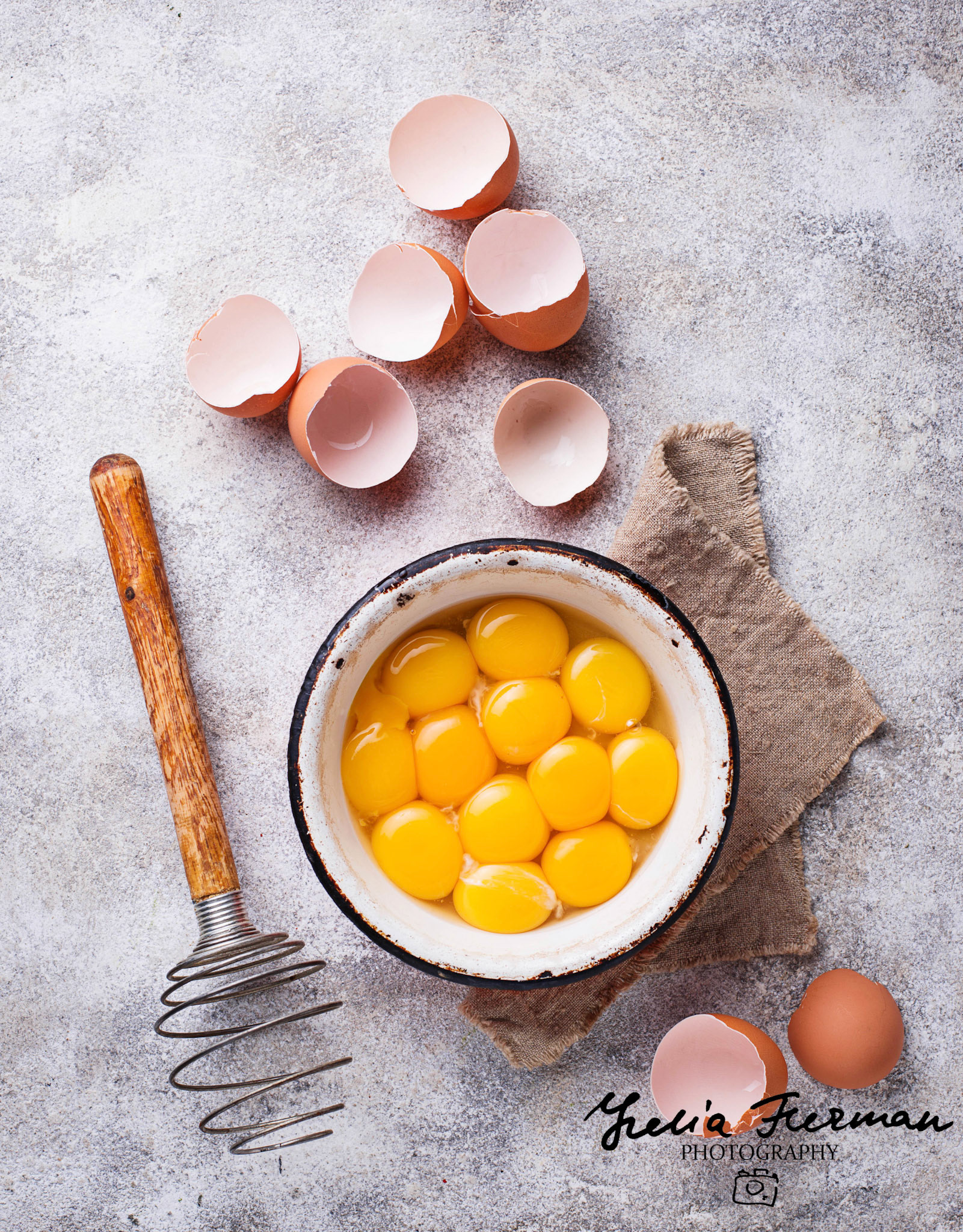 Bowl with eggs yolks and vintage whisk. Top view
