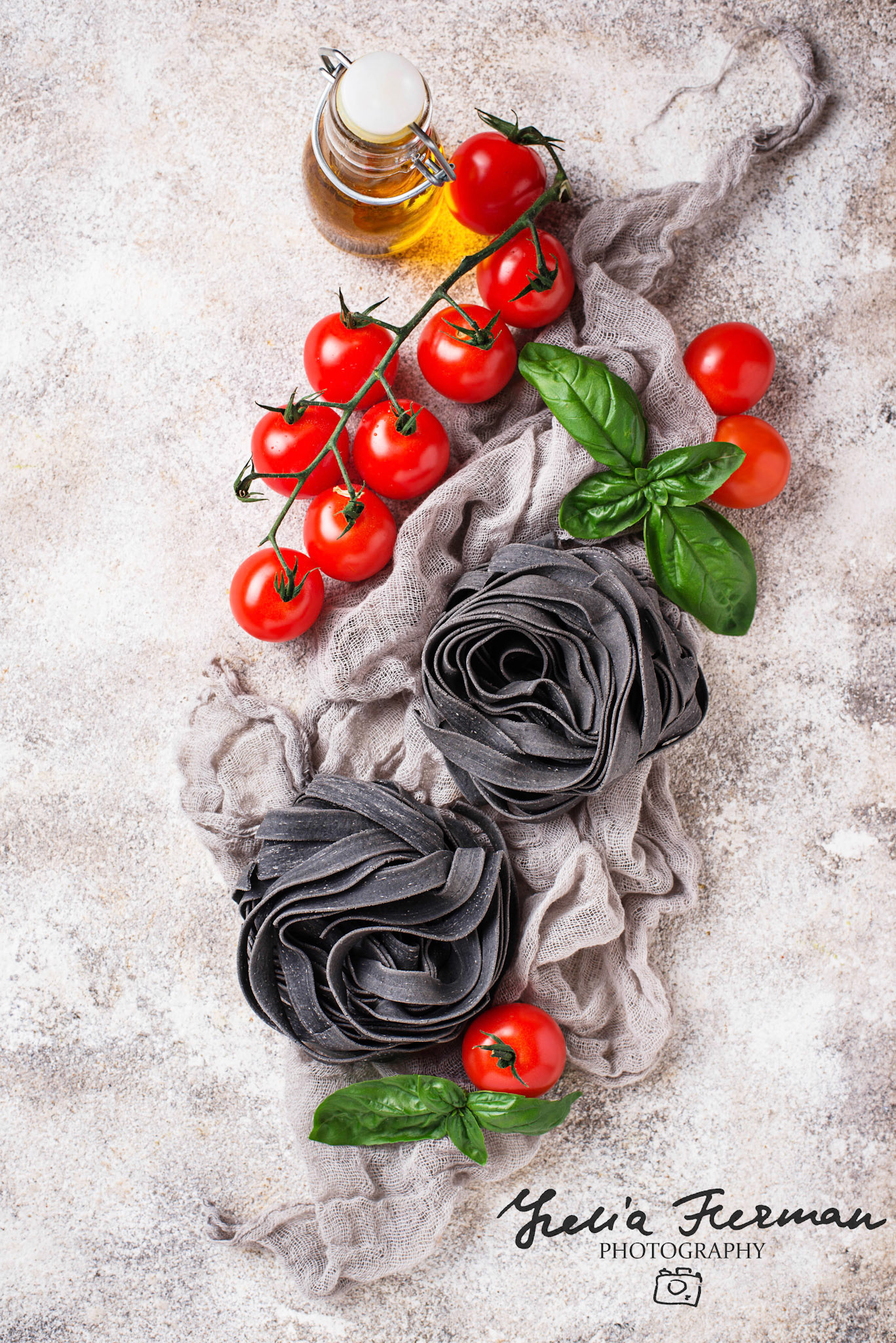 Black uncooked pasta tagliatelle with tomato and basil. Selective focus