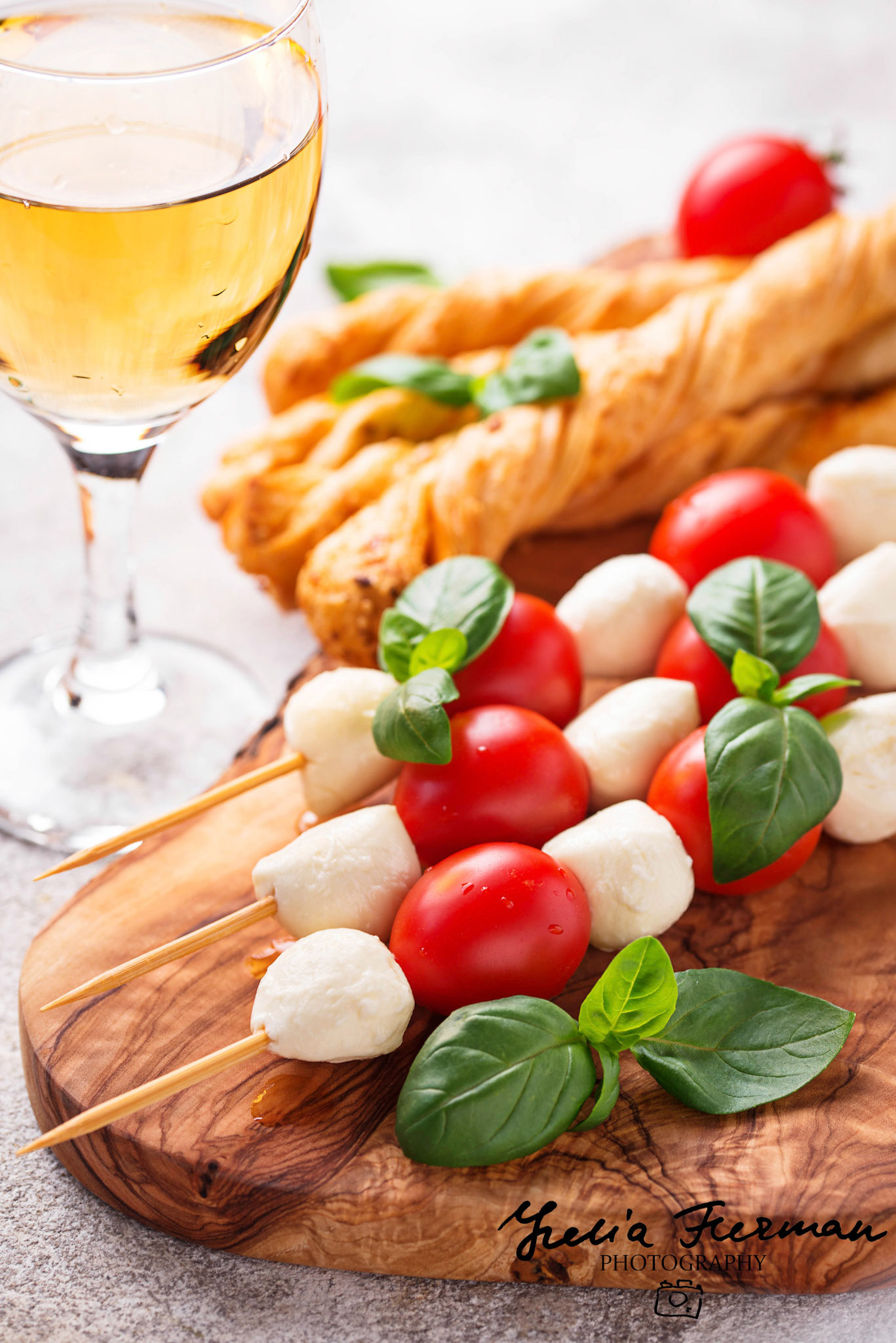 Traditional Italian antipasto caprese skewers and grissini bread