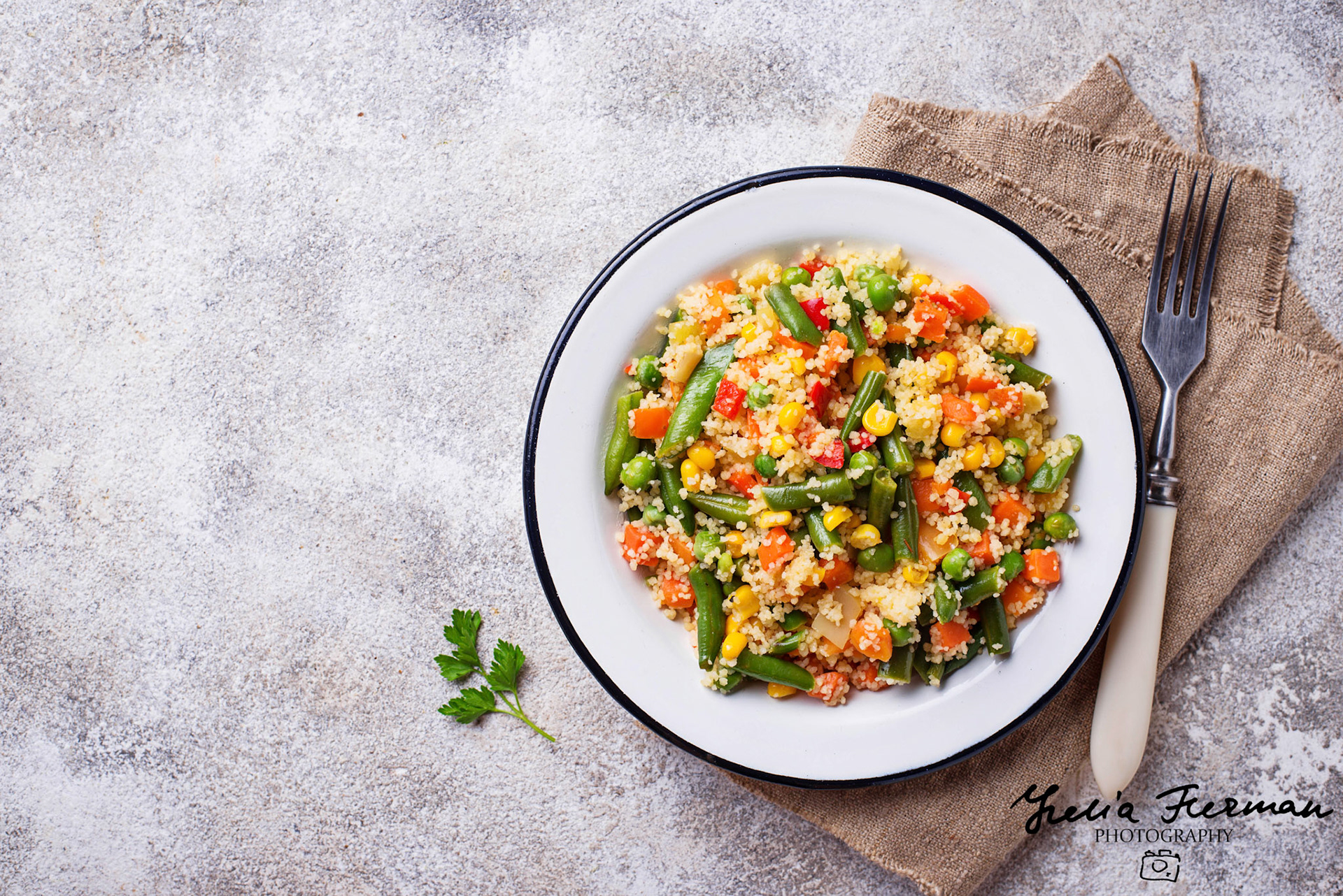 Vegetarian dish couscous with vegetables on light concrete table