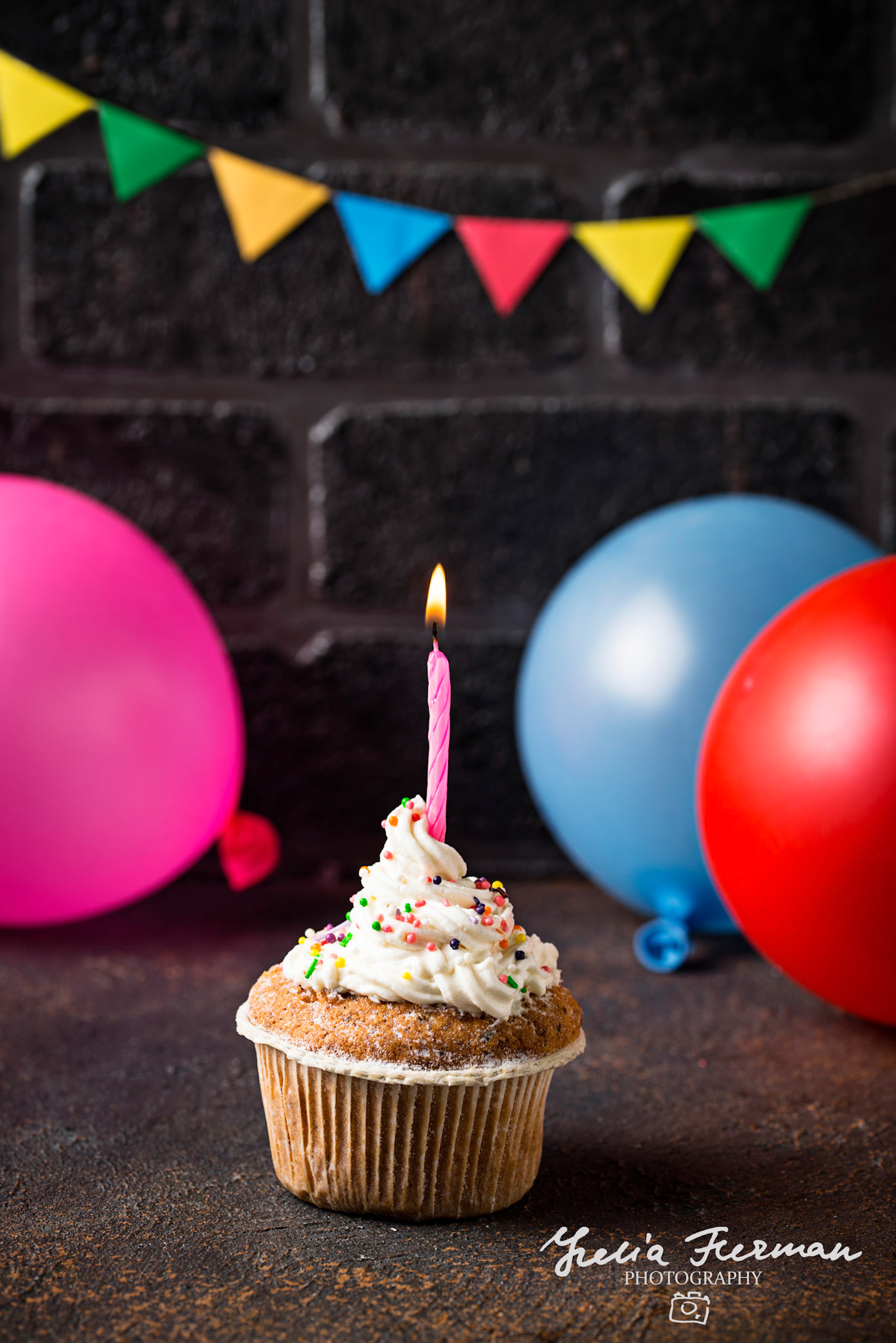 Birthday cupcake with cream and candle on brick wall background