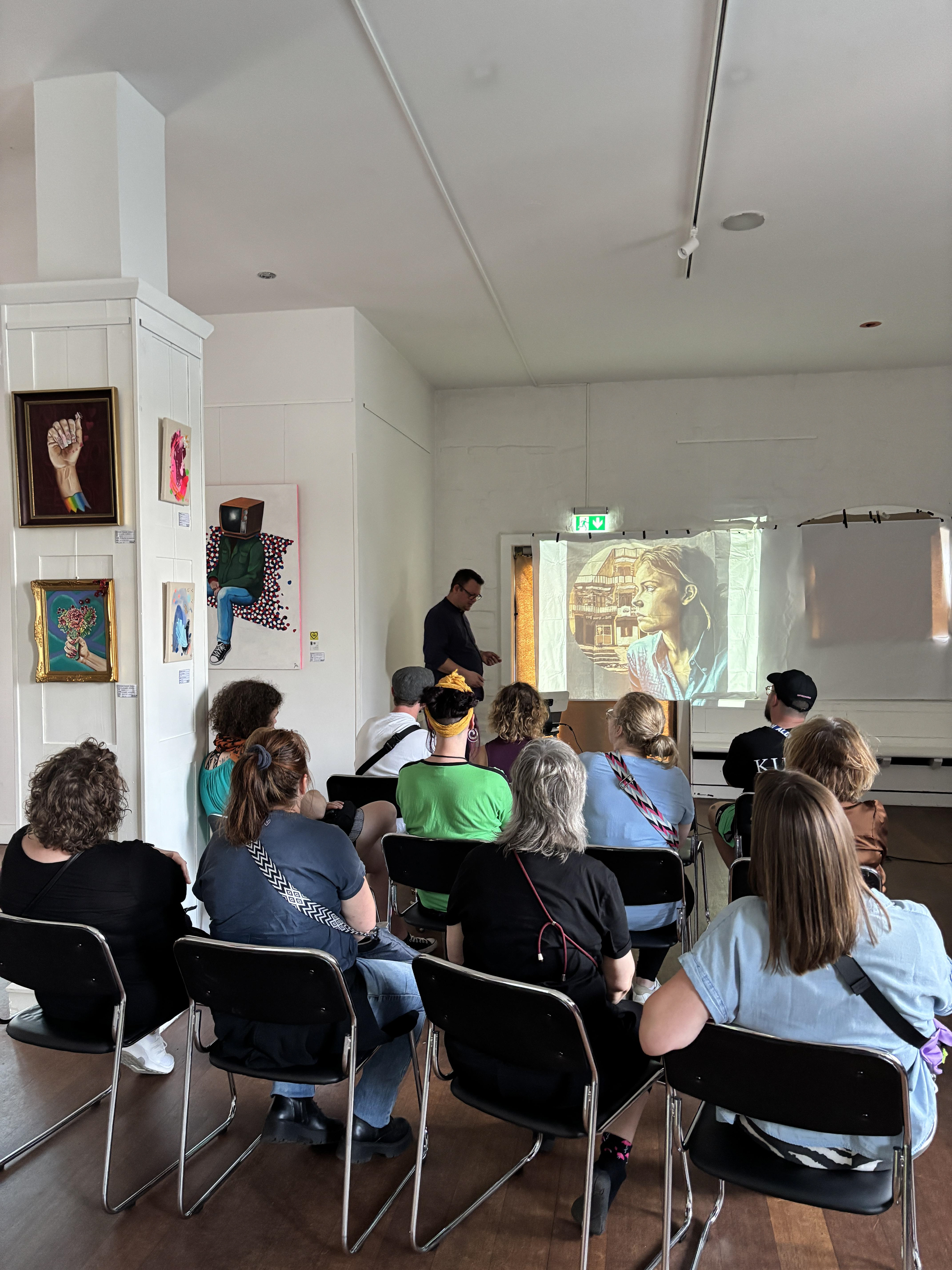 Ausstellung Kunst am Katzengraben 2025, Menschen sehen sich Präsentation über die Historie der Graffiti Kunst 